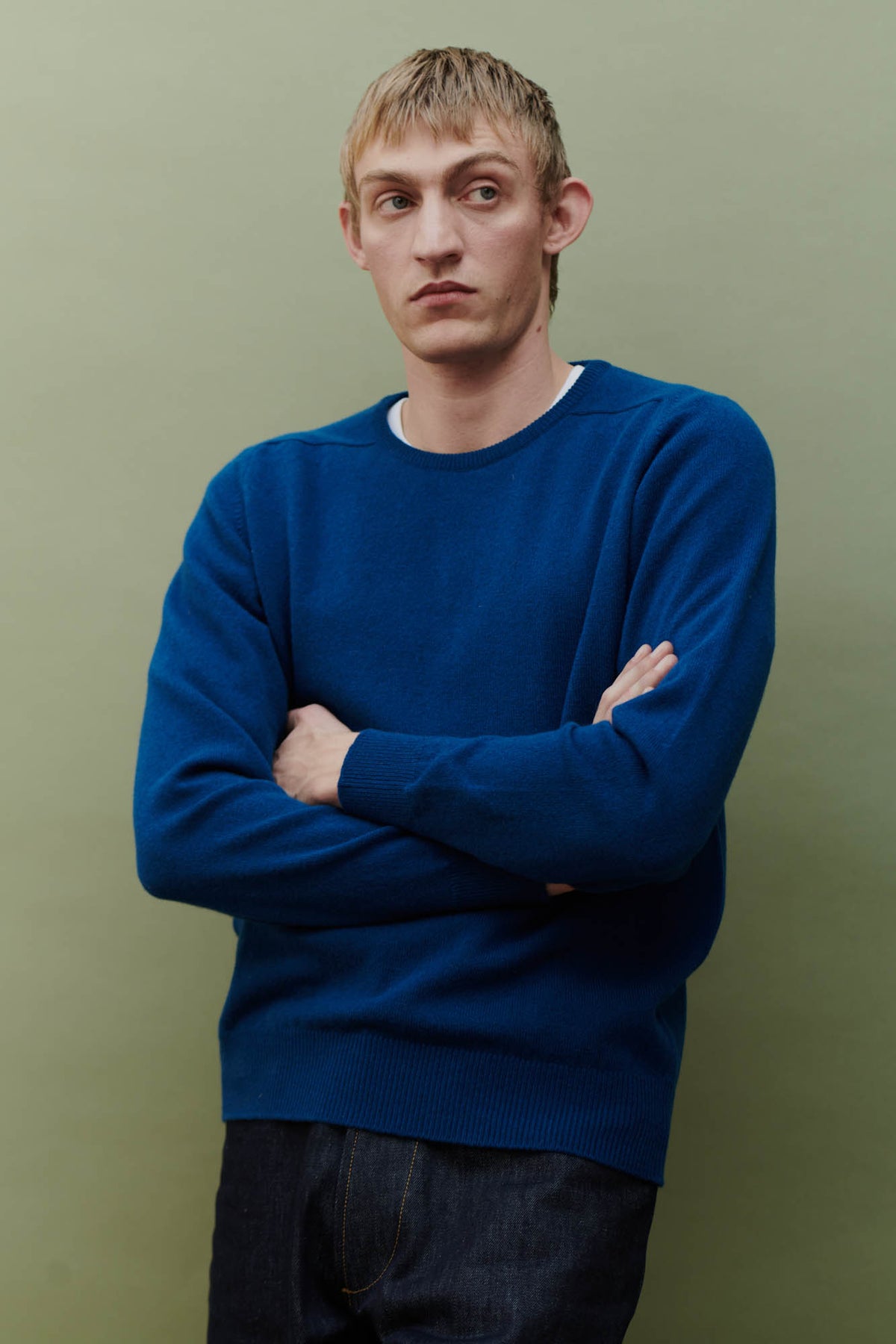 
            Image showing thigh above of white male wearing men&#39;s lambswool saddle shoulder crew neck with arms folded