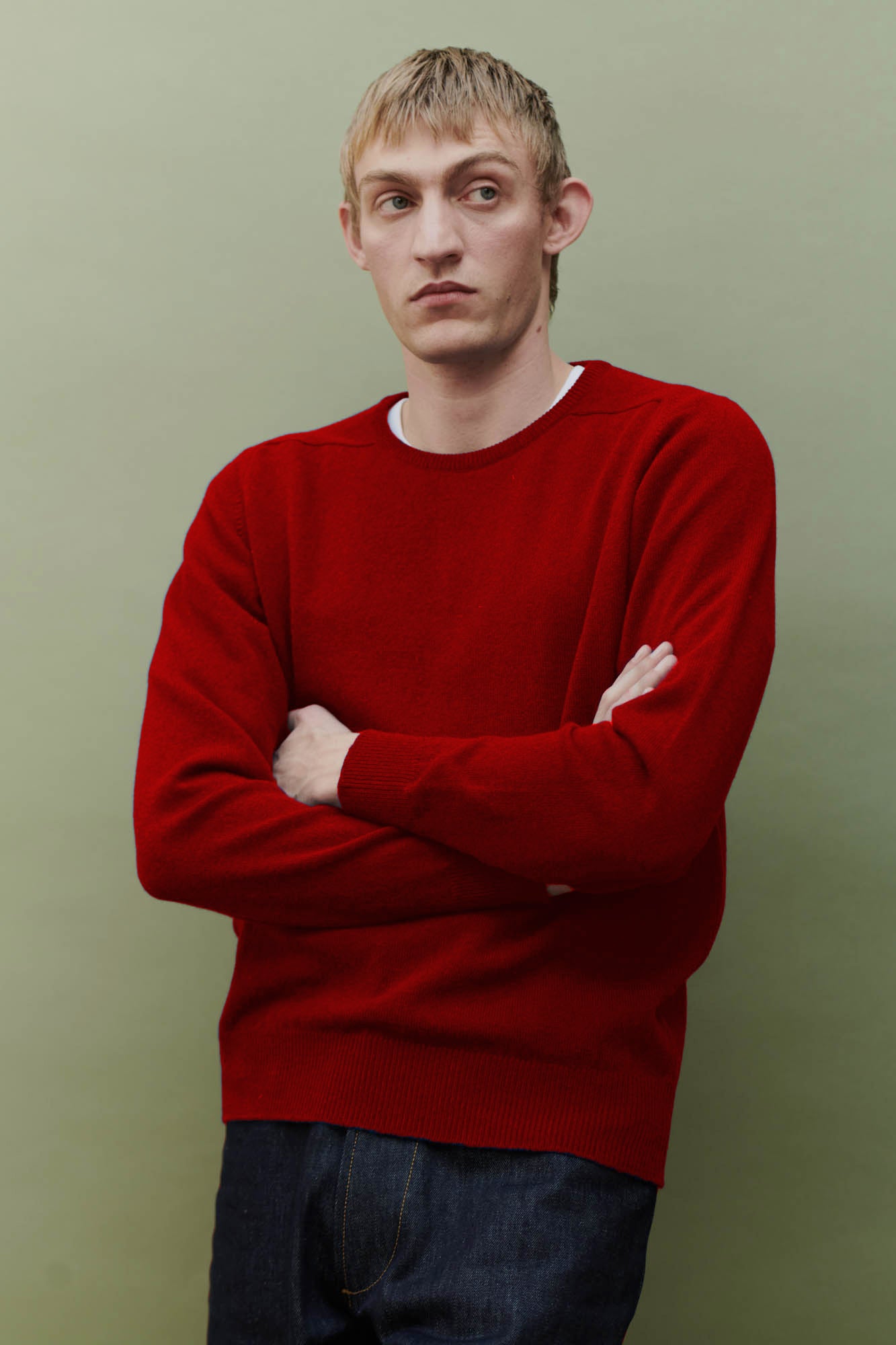Image of white male, thigh up, wearing lambswool saddle shoulder crew neck in red