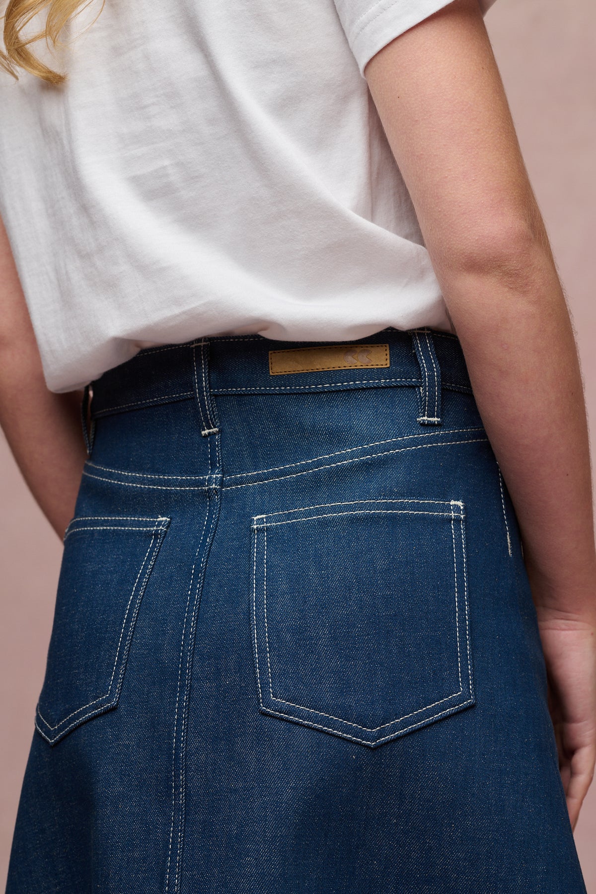 
            Close up image of the back of Bobbie a line denim midi skirt in blue waistband with jean patch and belt loops and two back pockets