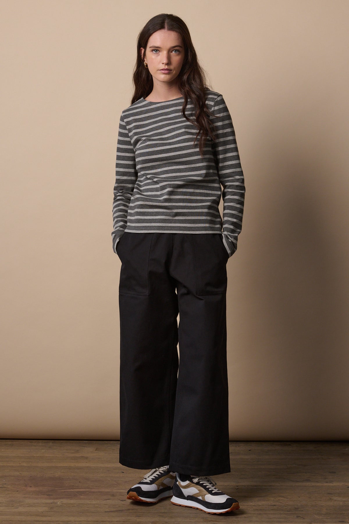 
            White female with long brunette hair wearing Breton in charcoal marl and grey marl paired with camerawoman pants in black