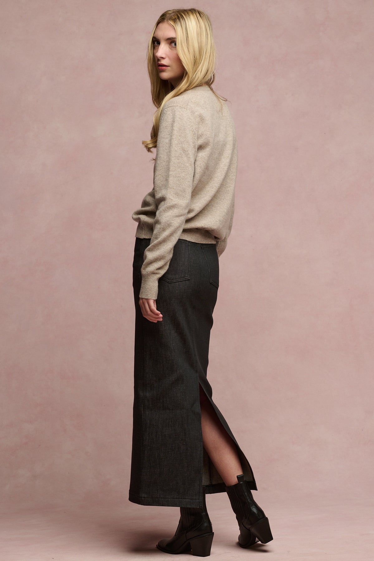 
            Image of the back of blonde female wearing lambswool jumper paired with Frankie denim maxi skirt with split hem and black boots
