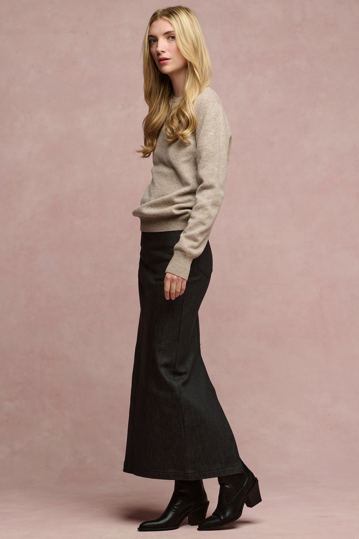 
            The side of female wearing Frankie denim maxi skirt in black paired with lambswool jumper and black boots