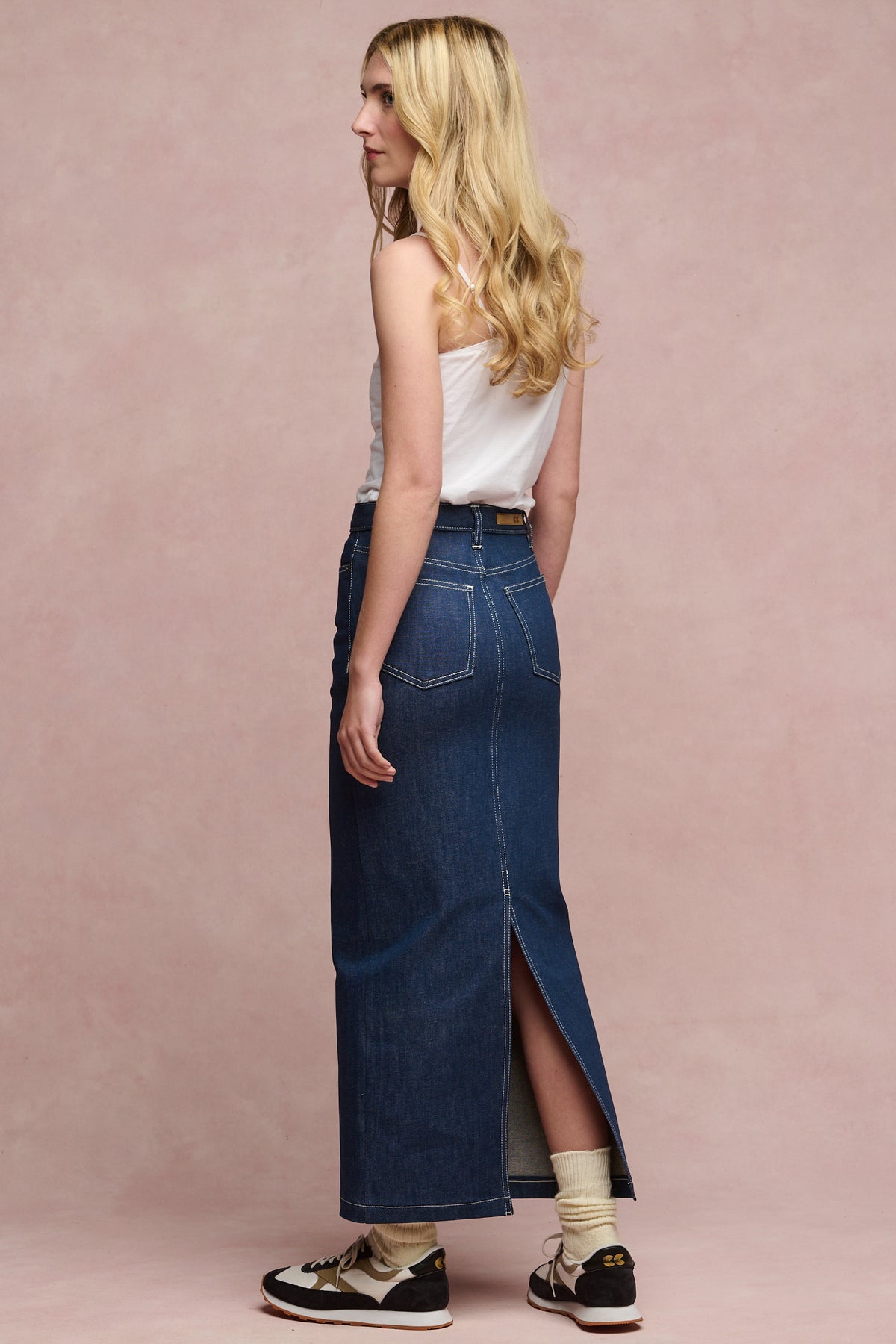 
            Full body image of the back Frankie denim maxi skirt in blue paired wth white camisole and beacon trainers in white/charcoal