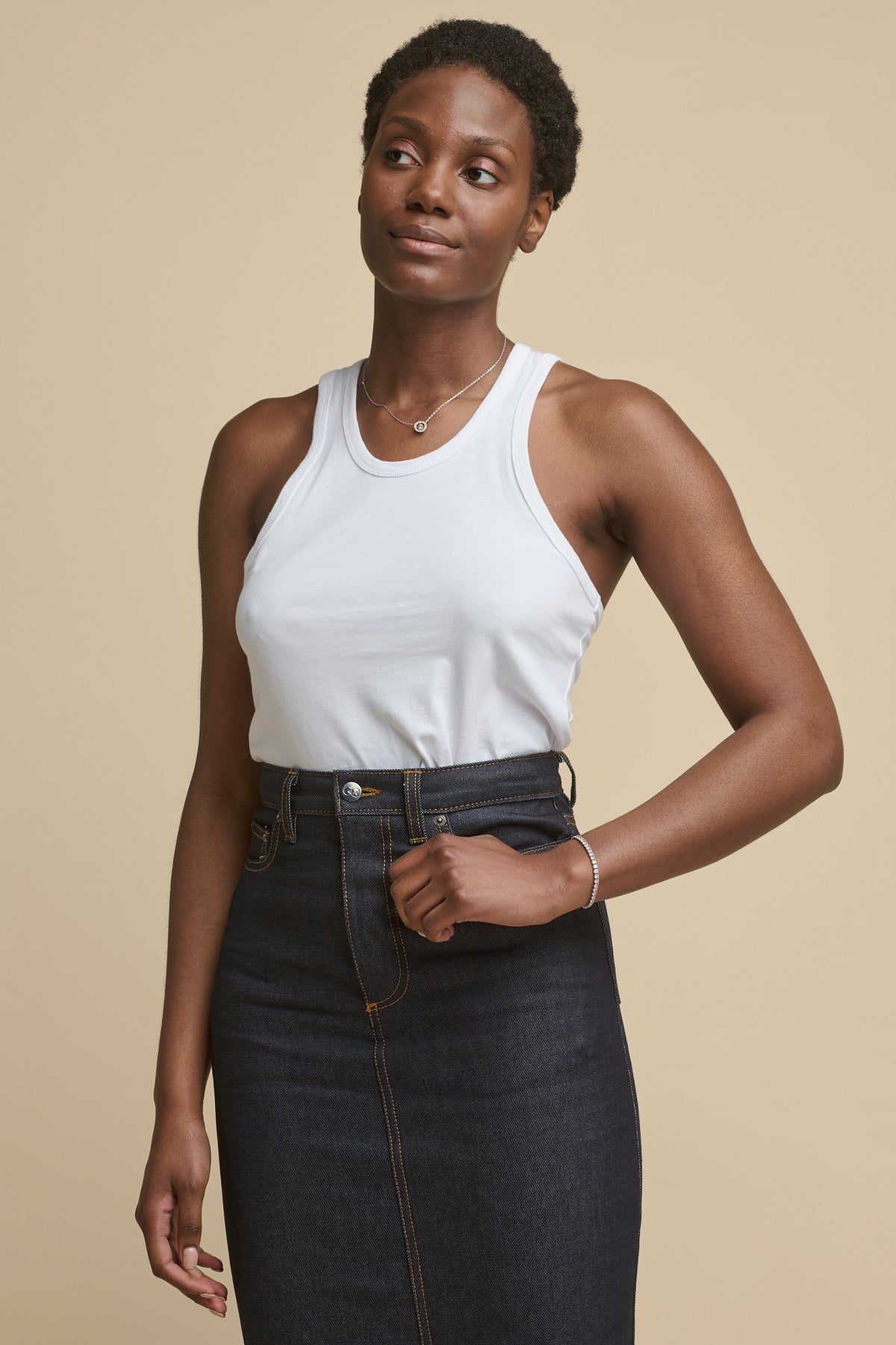 
            Thigh up image of the front of black female wearing racer back vest in white