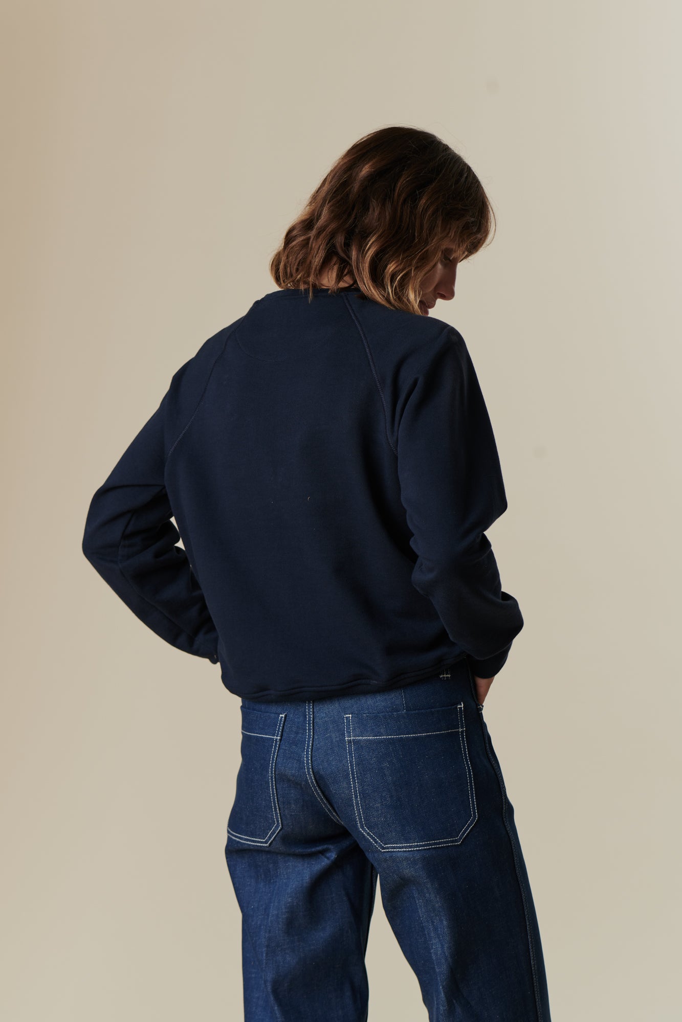 image of back of female wearing women's raglan sweatshirt in navy