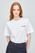 Thigh up of female with ginger hair wearing white t shirt with black Community logo on chest