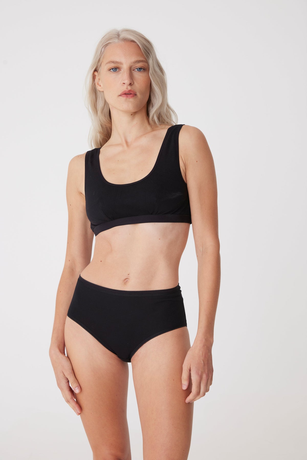 
            white, blonde female wearing black soft jersey bra paired with black high rise brief 