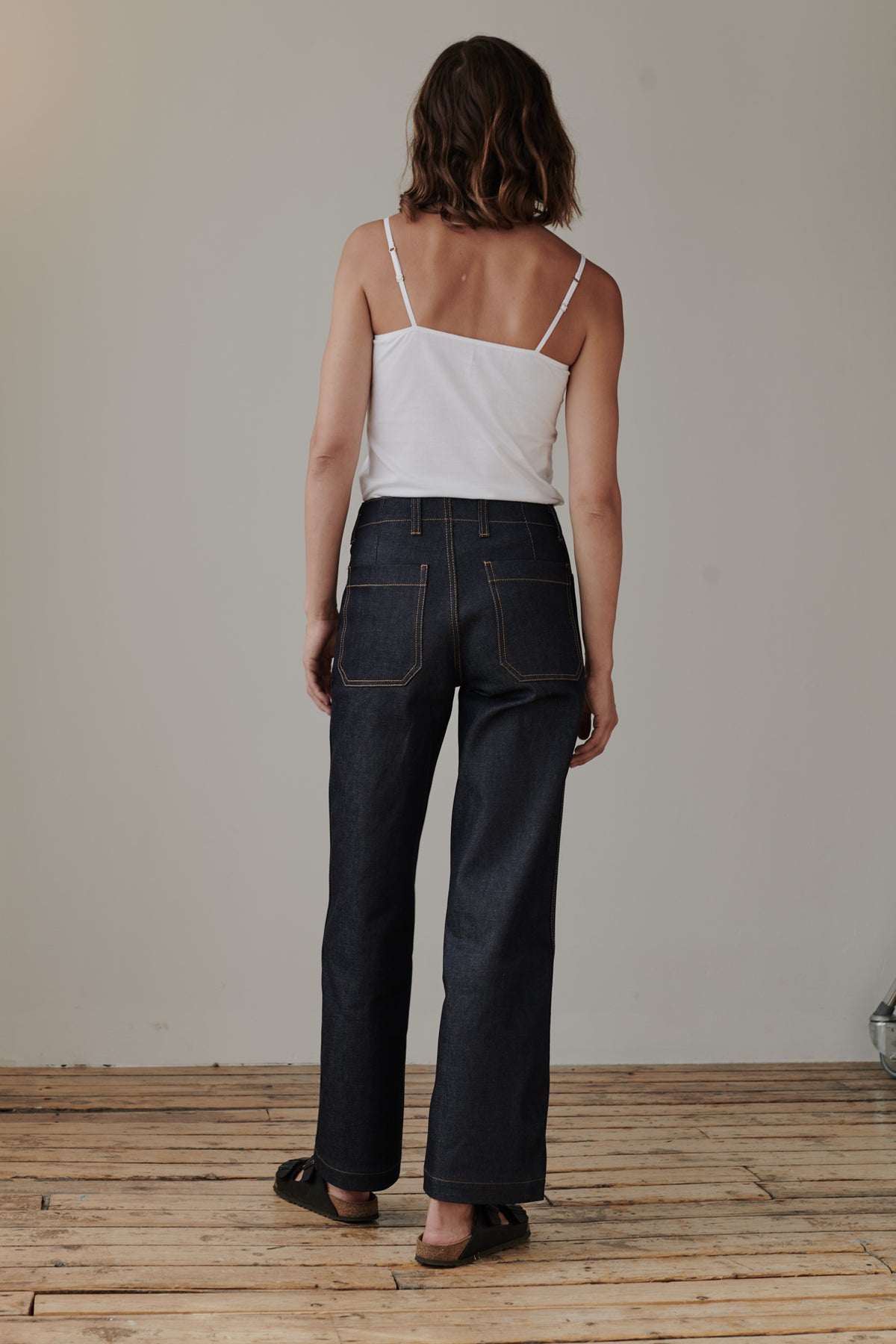 
            Full body image of behind of female wearing work jean indigo