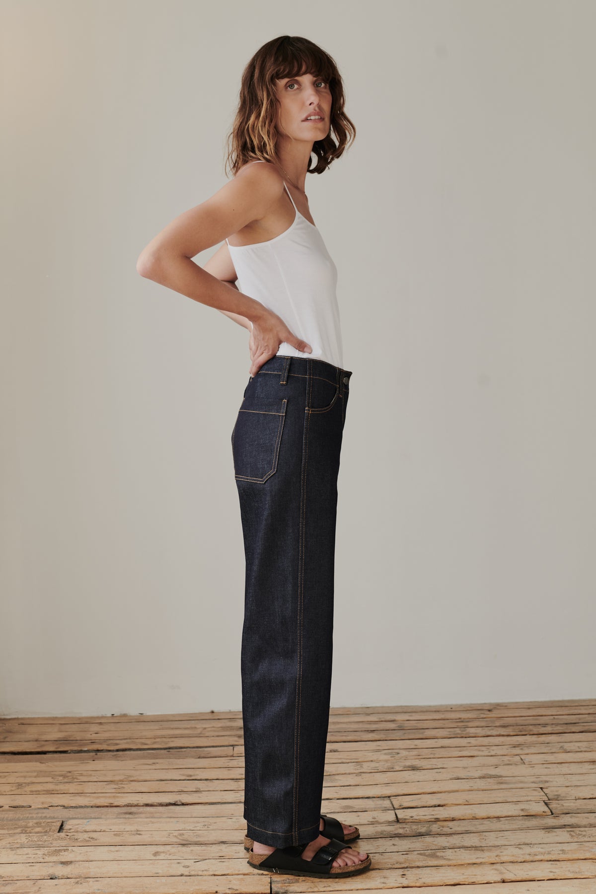 
            Full body side image of brunette female wearing work jean in indigo.