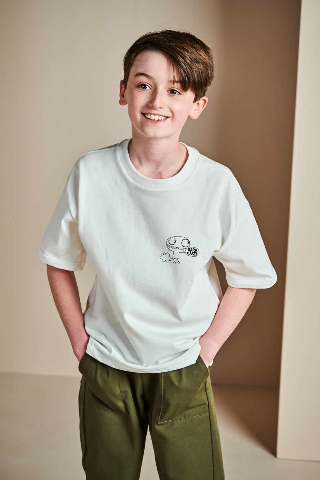 Smiley young girl wearing short sleeve t shirt in bone with barm cake! print on chest