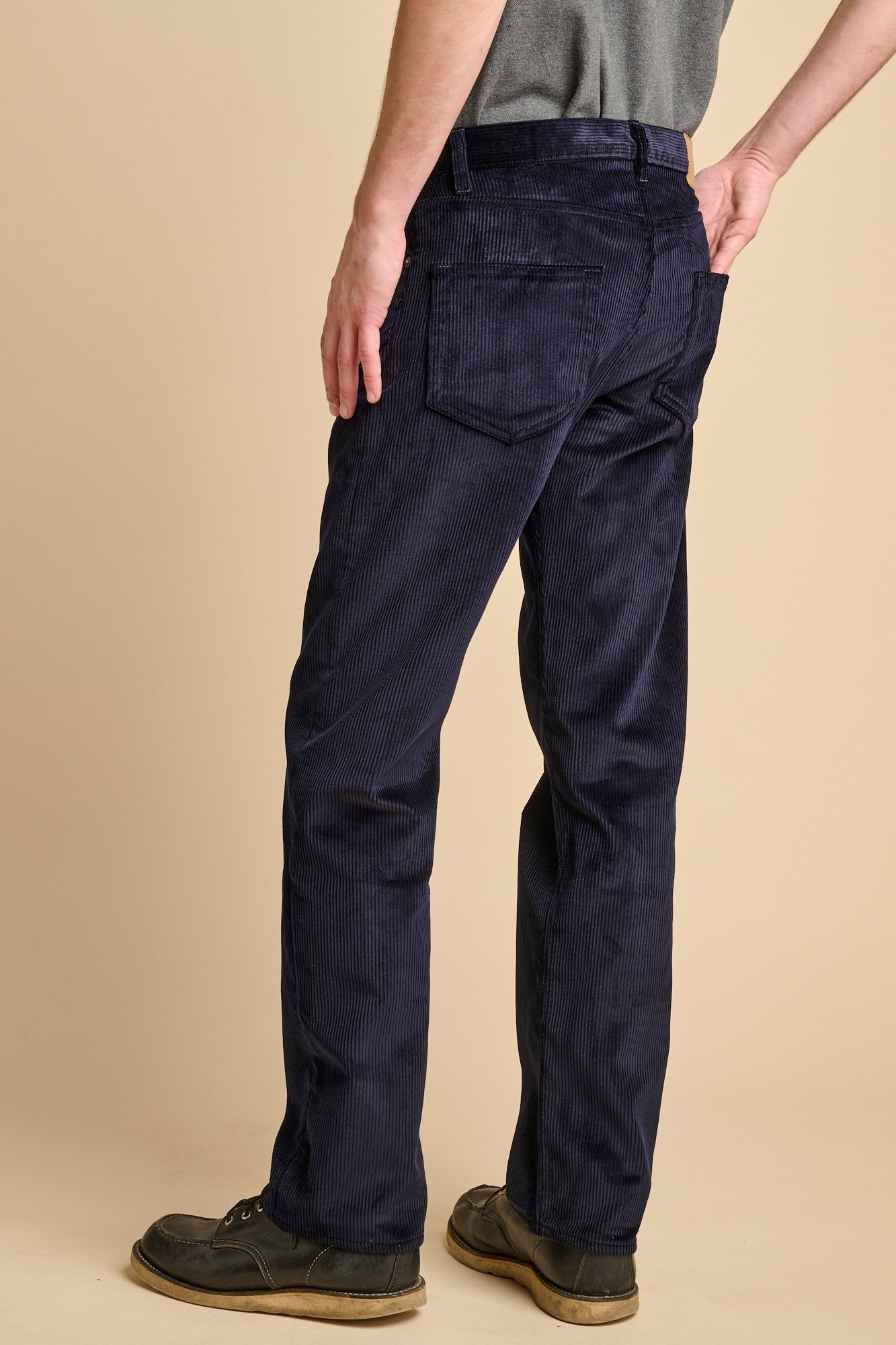 The back of man wearing navy corduroy straight leg jeans.
