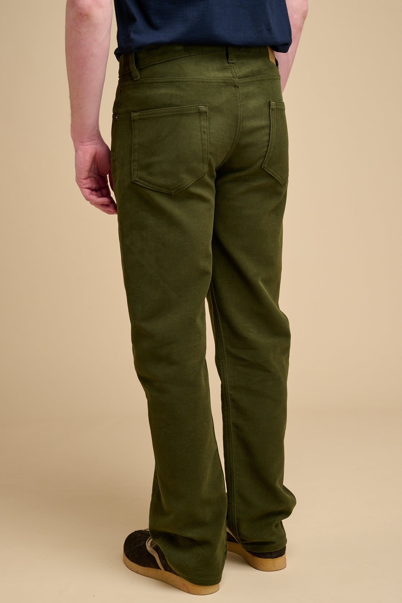The back of male dark olive wearing moleskin jeans.