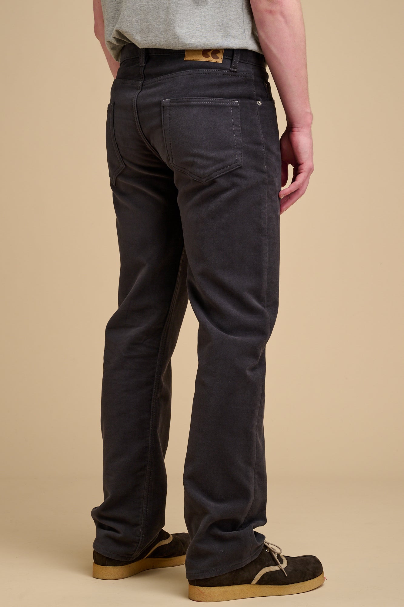 The back of male wearing moleskin jeans in slate grey.