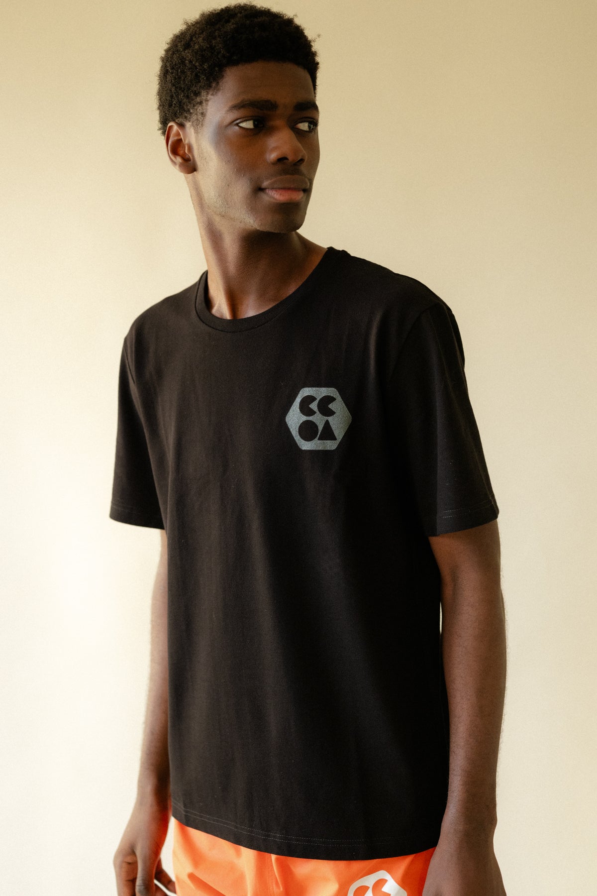 
            Black male wearing breathable short sleeve t shirt in black with CCOA logo