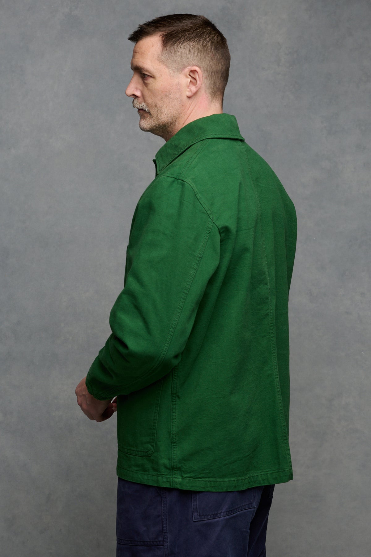 
            Thigh up image of the back of Patrick Grant wearing men&#39;s chore jacket in bottle green