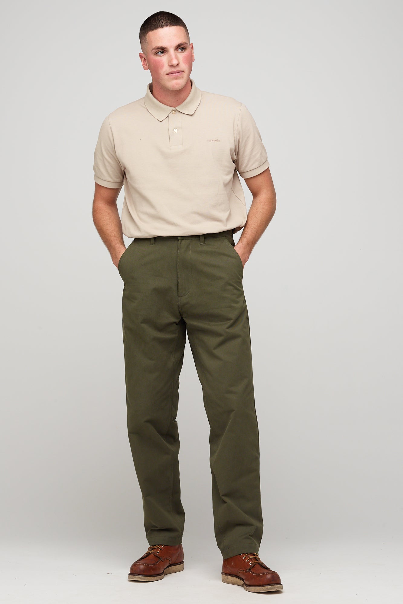 White, brunette male in olive heavyweight relaxed chino styled with short sleeve polo shirt in stone