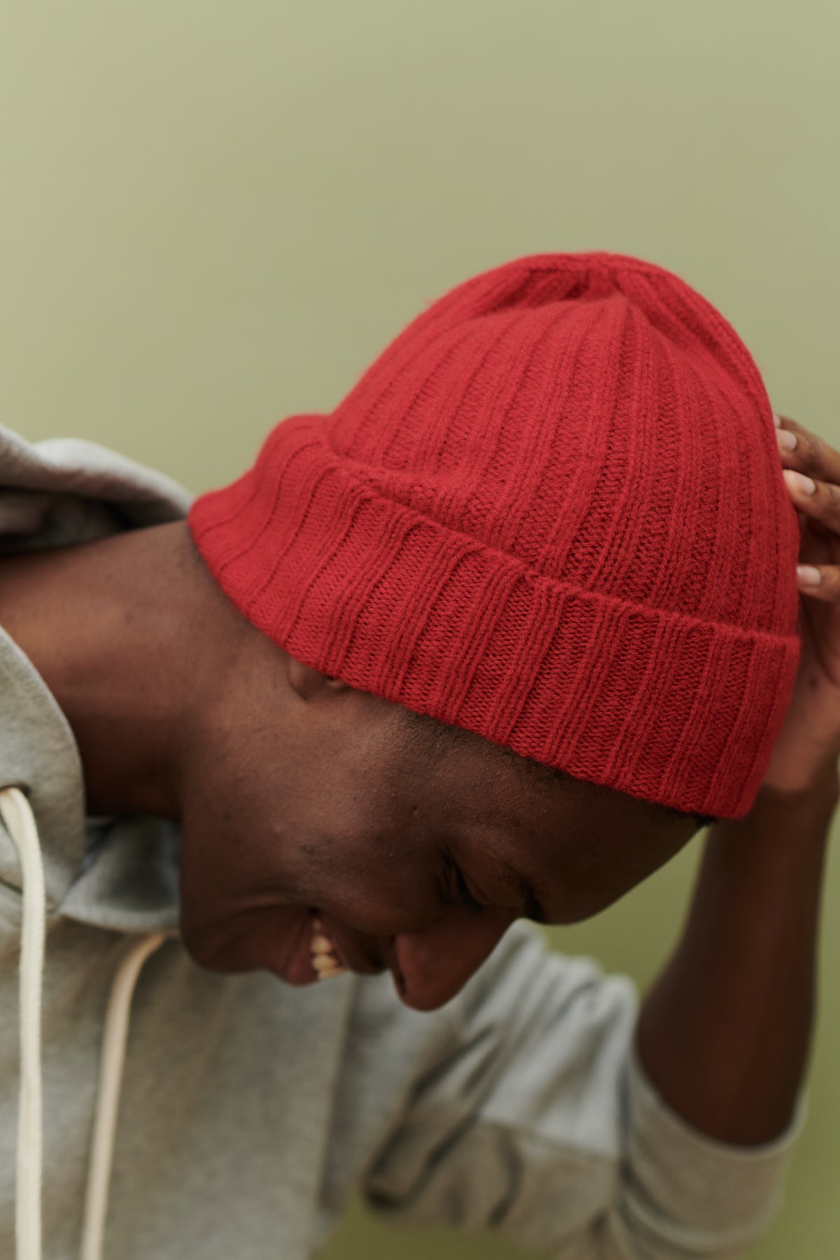 
            Male wearing unisex lambswool beanie hat in red