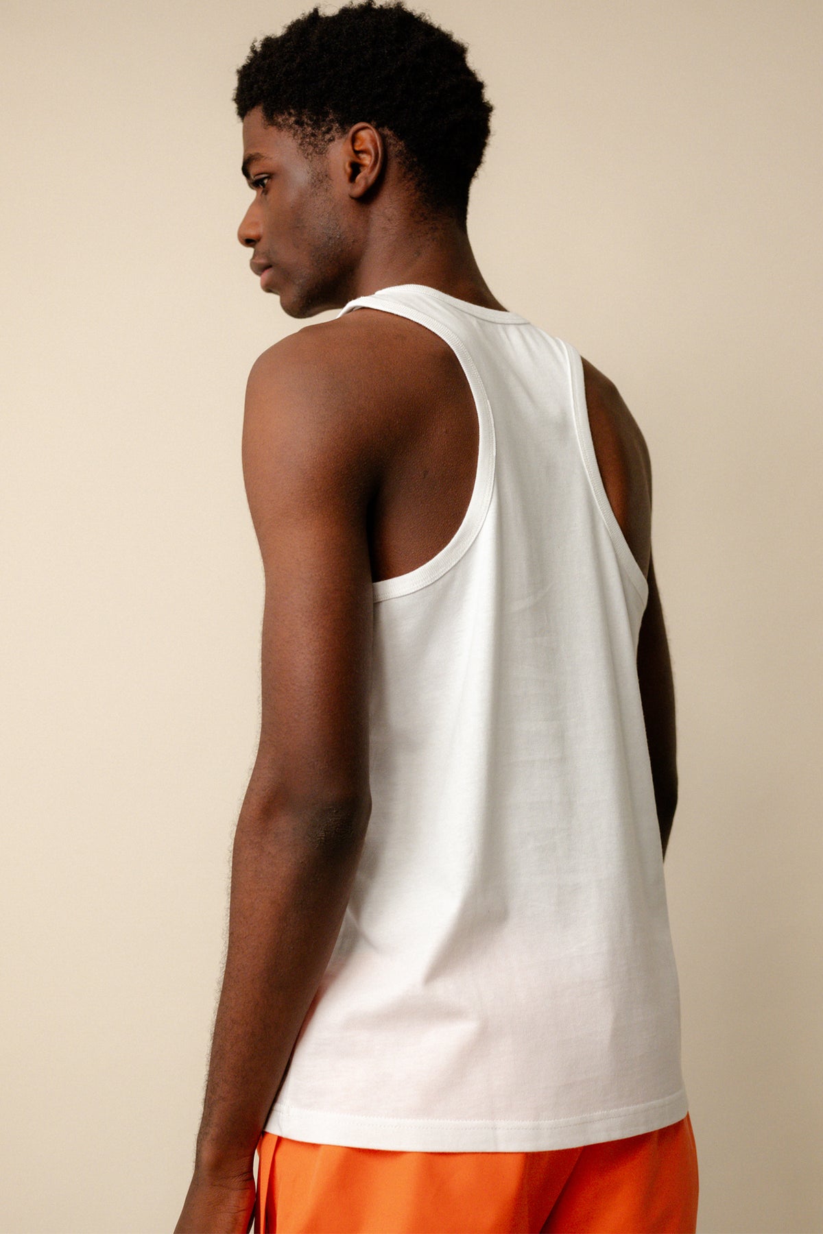 
            Back of black male wearing racer back vest plastic free in white