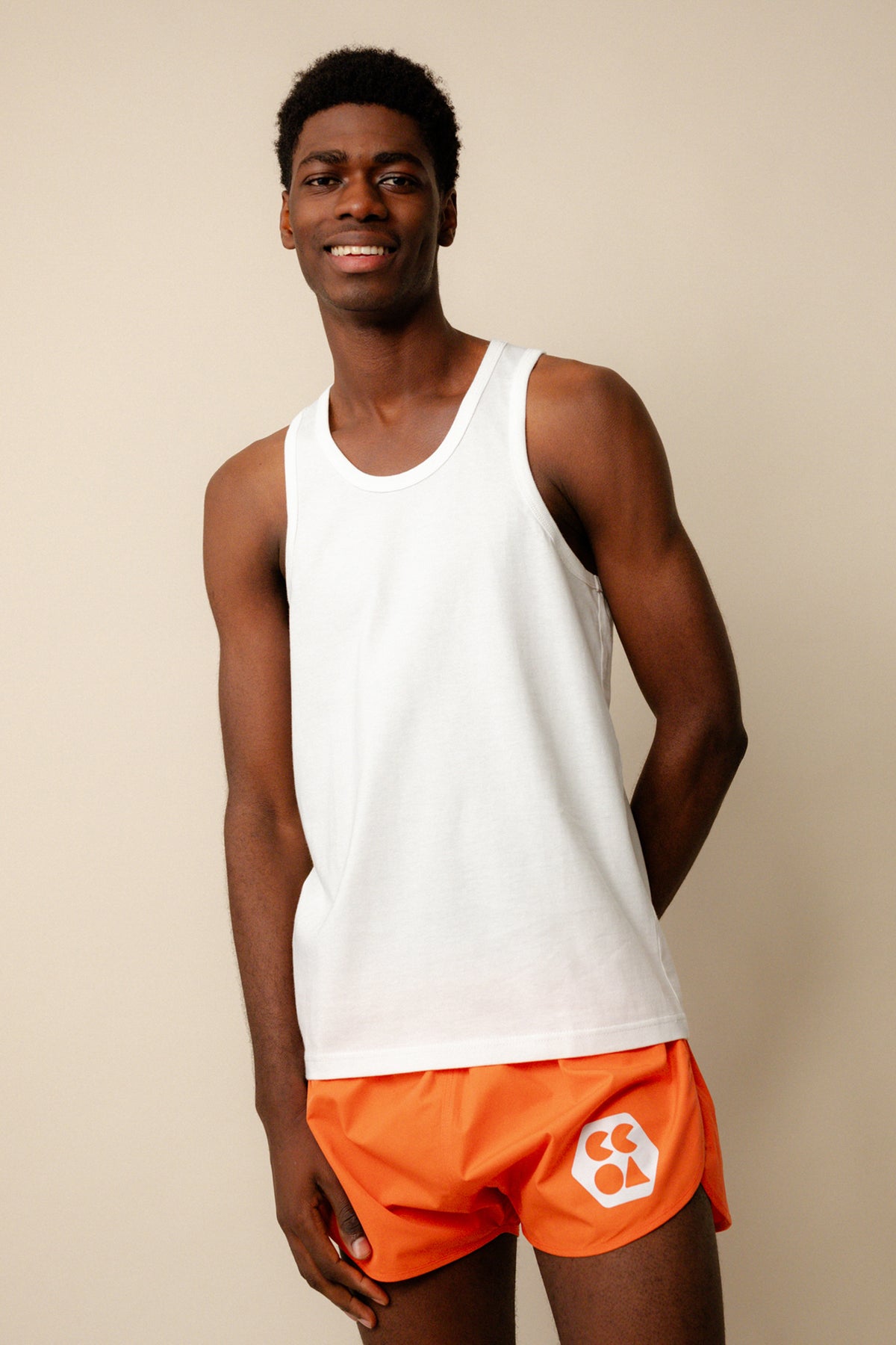 
            Smiley black male wearing racer back vest plastic free in white paired with lightweight running shorts