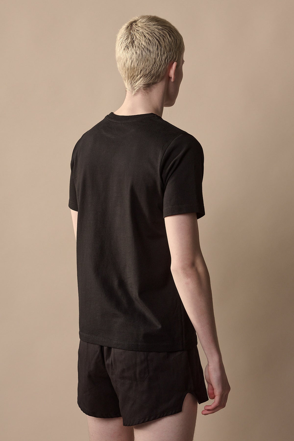 
            Thigh up image of the back of white male wearing short sleeve t shirt plastic free in black 