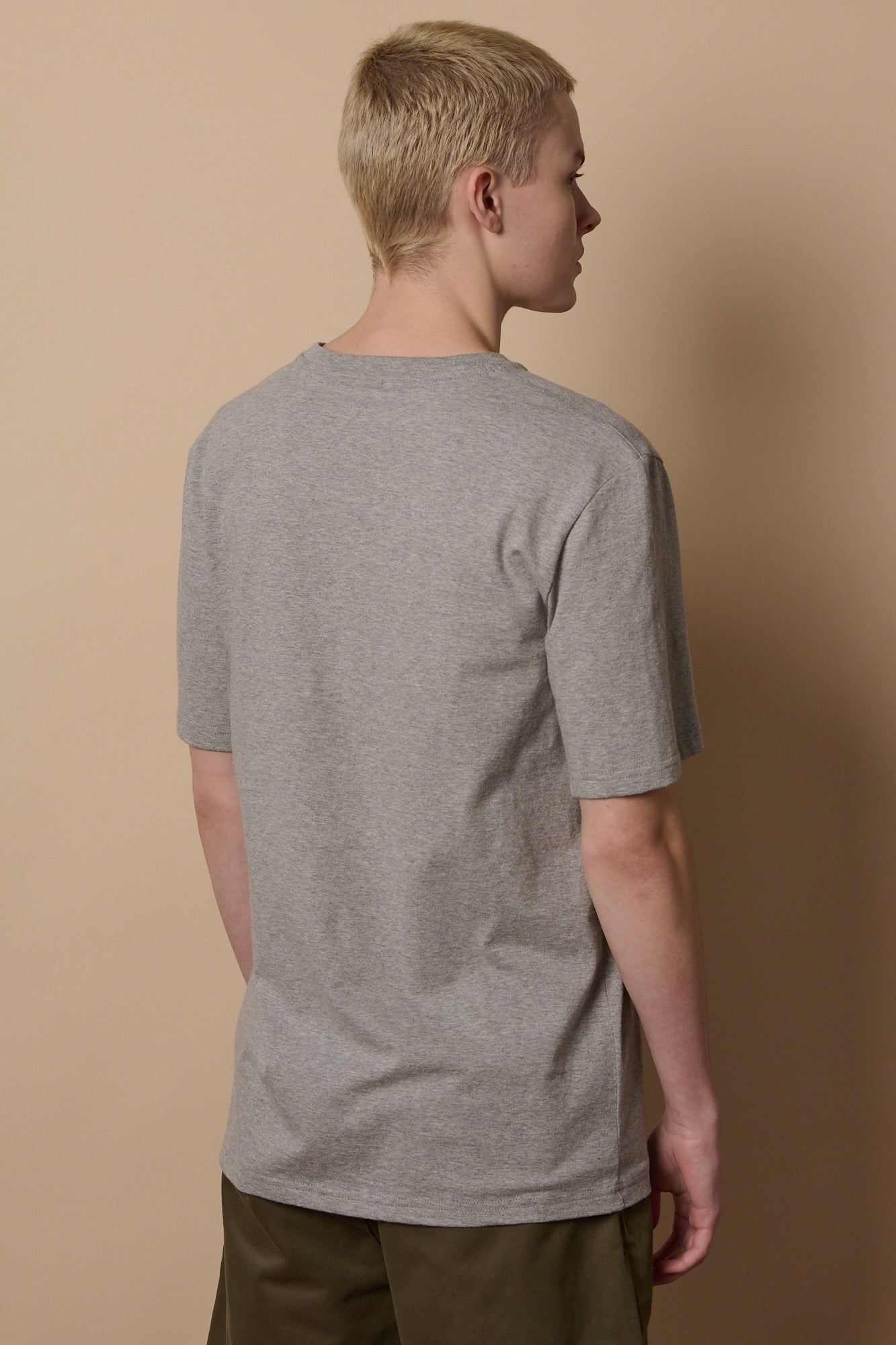 Back of white male wearing short sleeve t shirt in grey