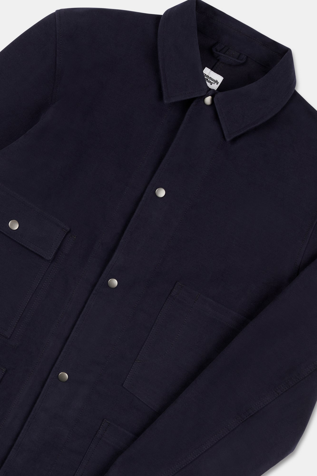 Close up flatlay of mens Carter moleskin chore jacket in navy.