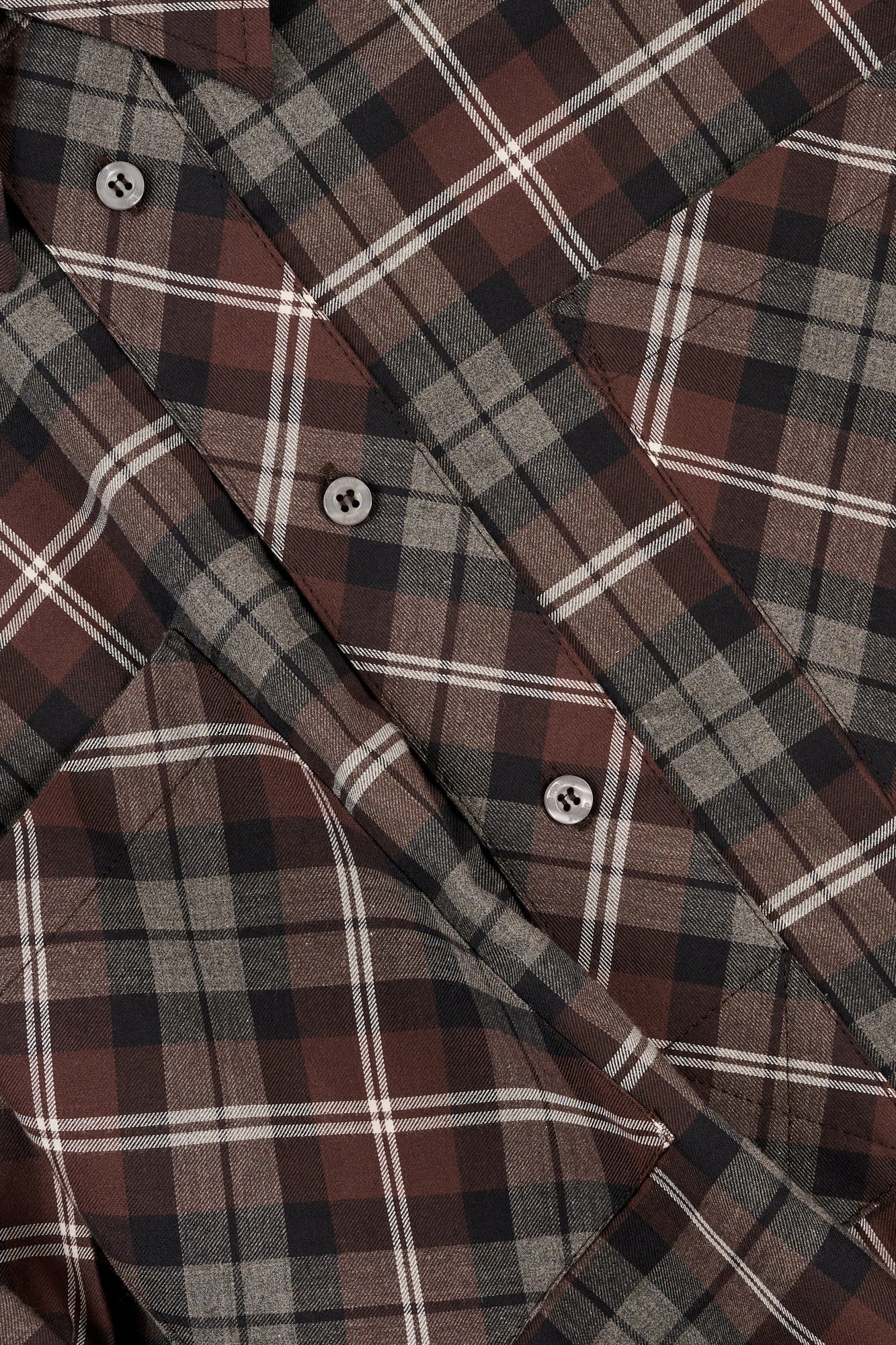 Close-up of a check shirt with brown, grey, and white.