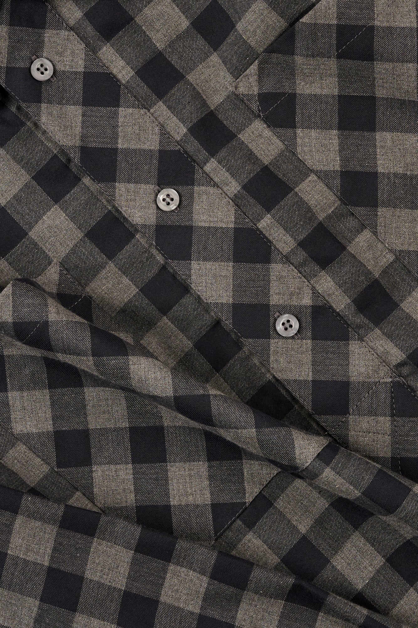 Close-up of a grey and navy checkered fabric with buttons.