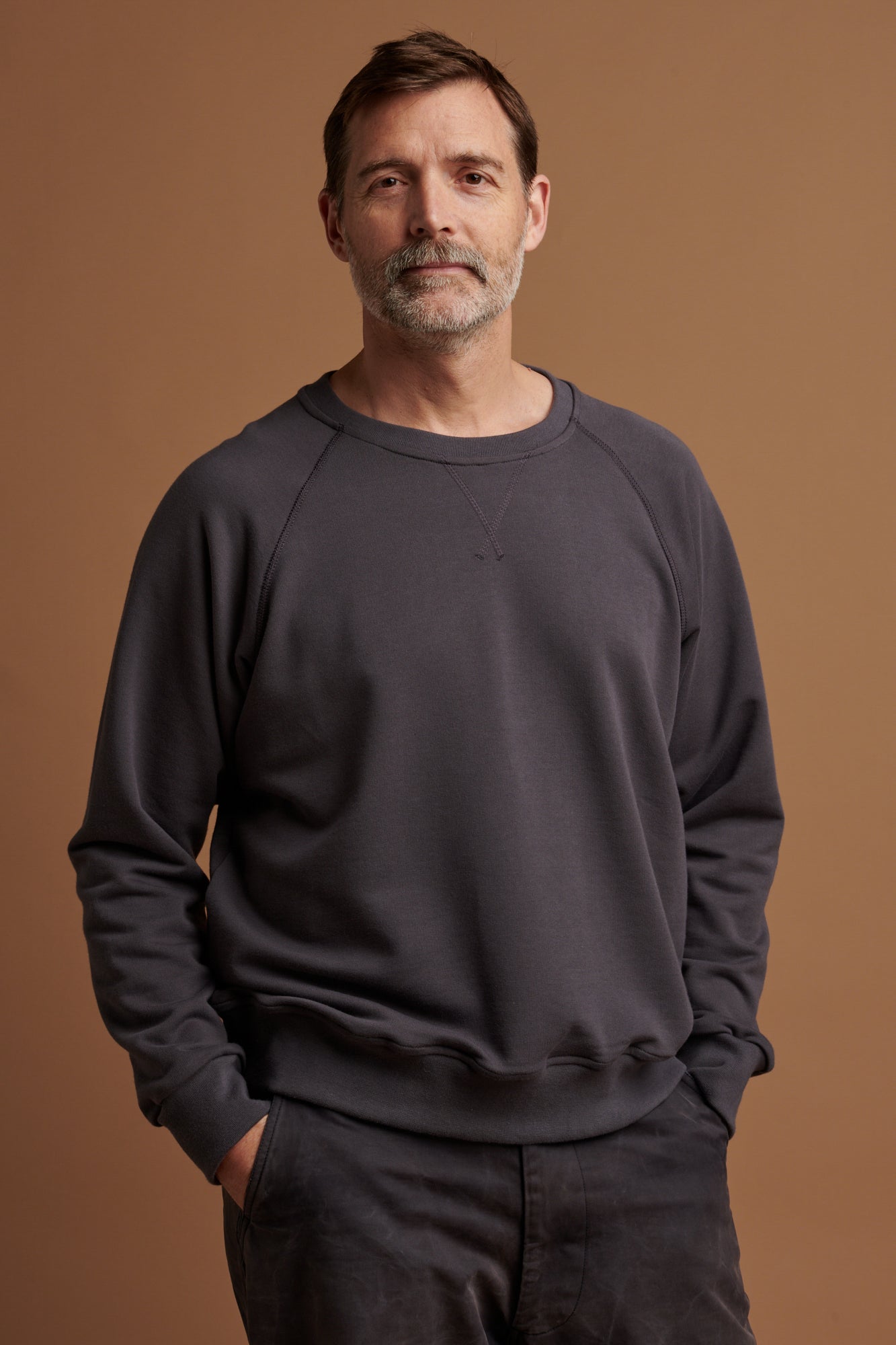 The front of Patrick wearing slate grey raglan sweatshirt