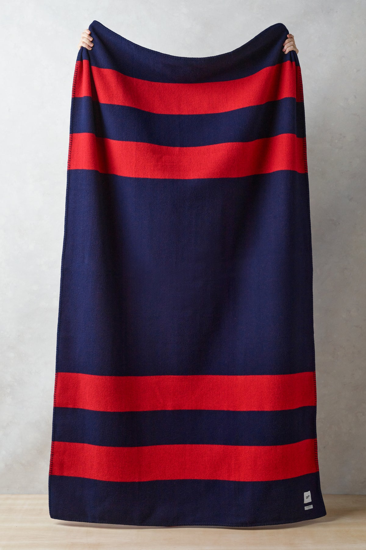 
            Image showing full length of navy and red striped pure merino wool blanket