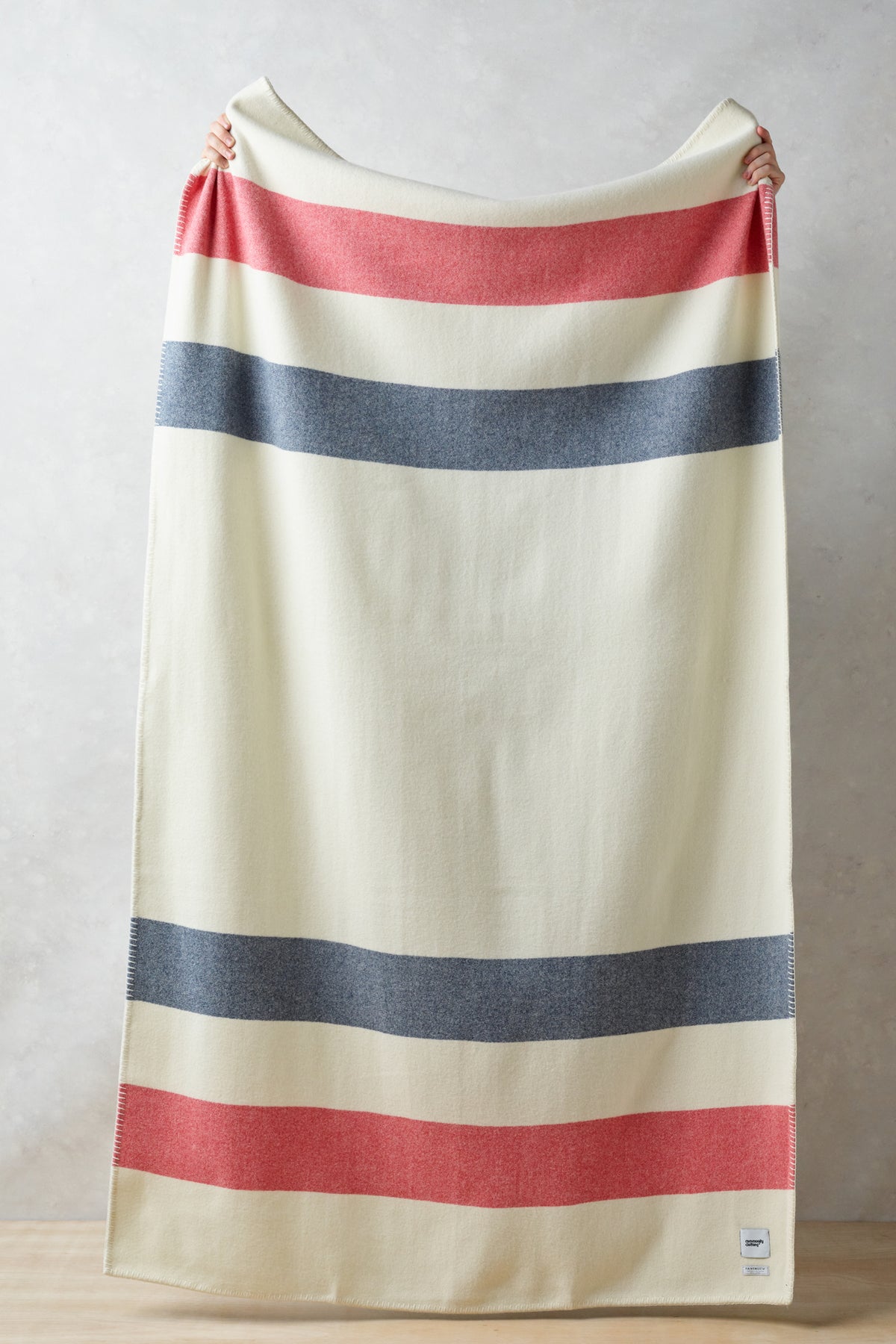 
            Full length of pure wool striped blanket in ecru red navy