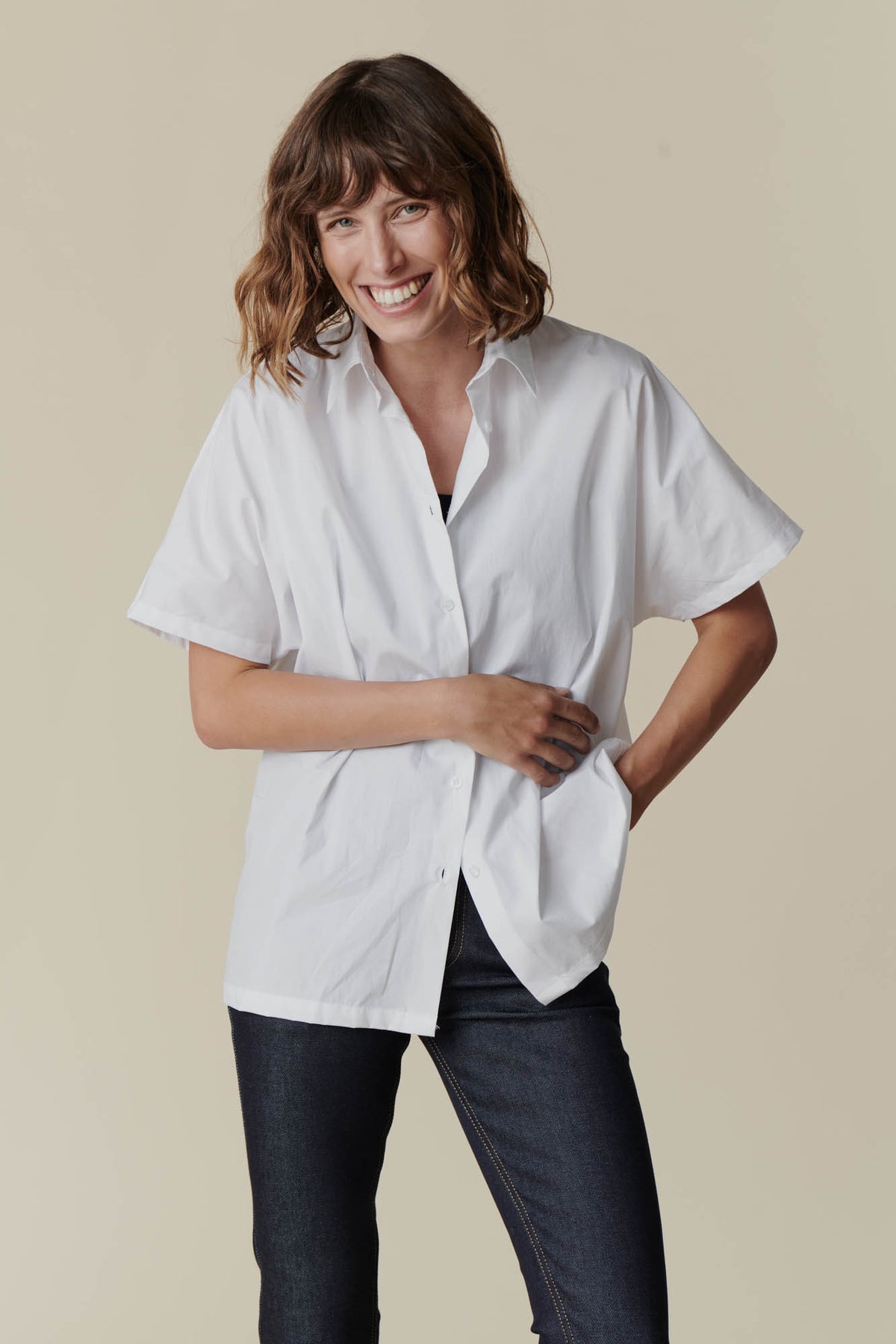 
            Female wearing Ava short sleeve shirt in white over black camisole 