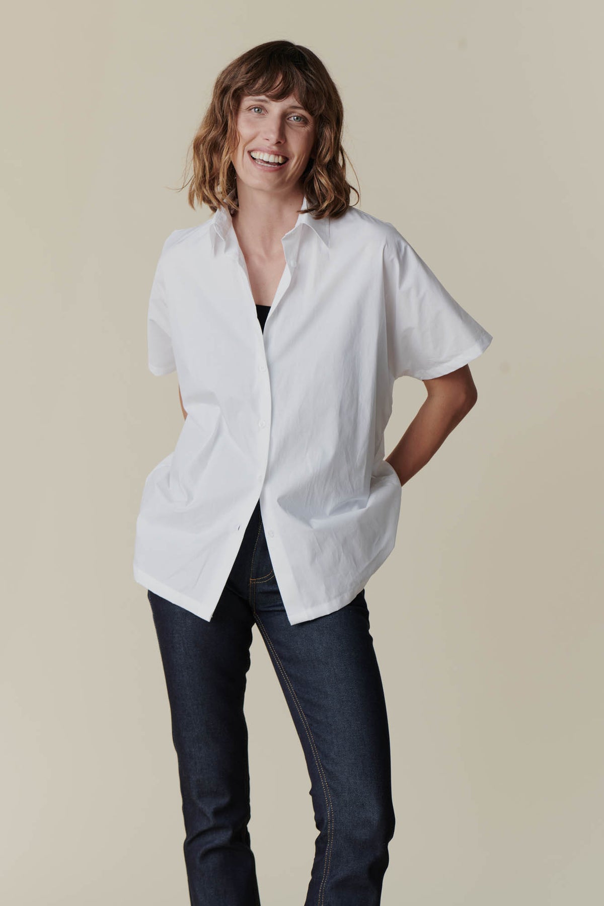 
            Female wearing Ava short sleeve shirt in white over black camisole 