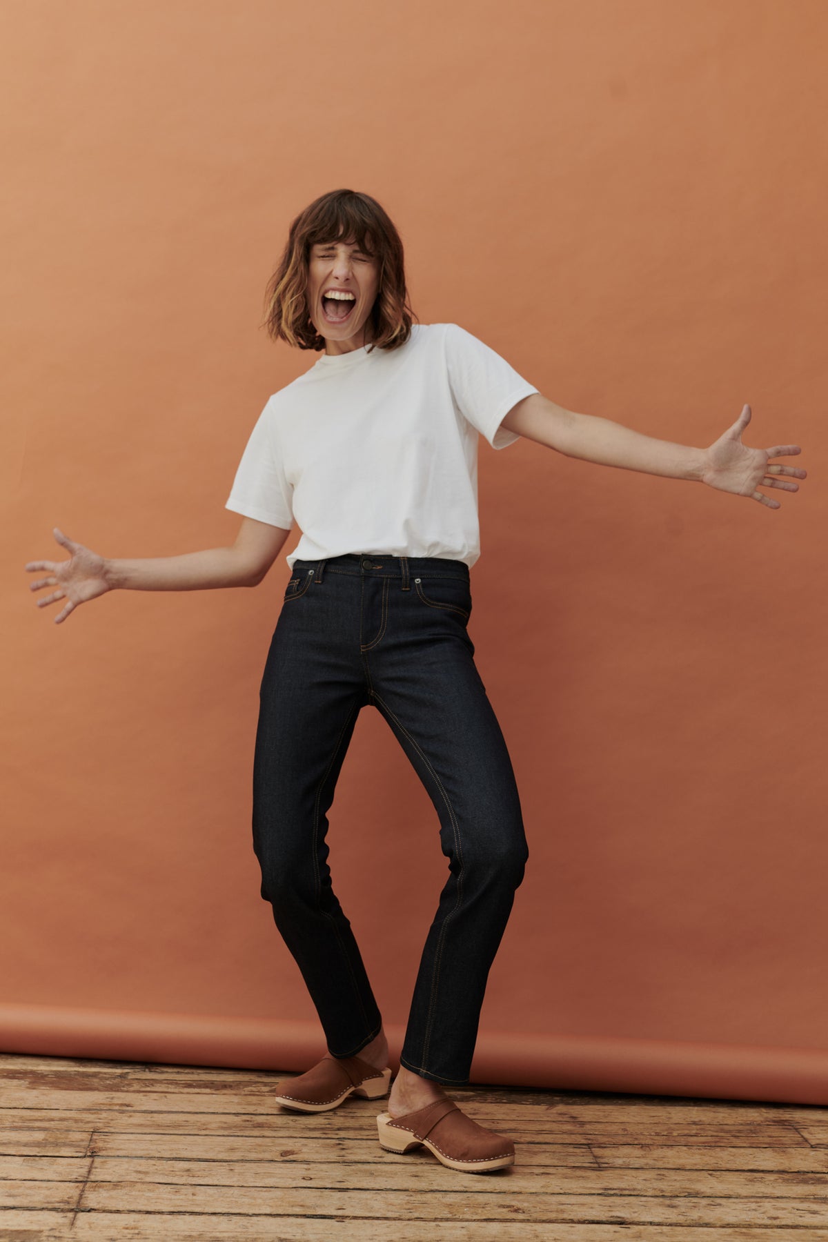 Full body image of female wearing mid rise straight leg jean in indigo.