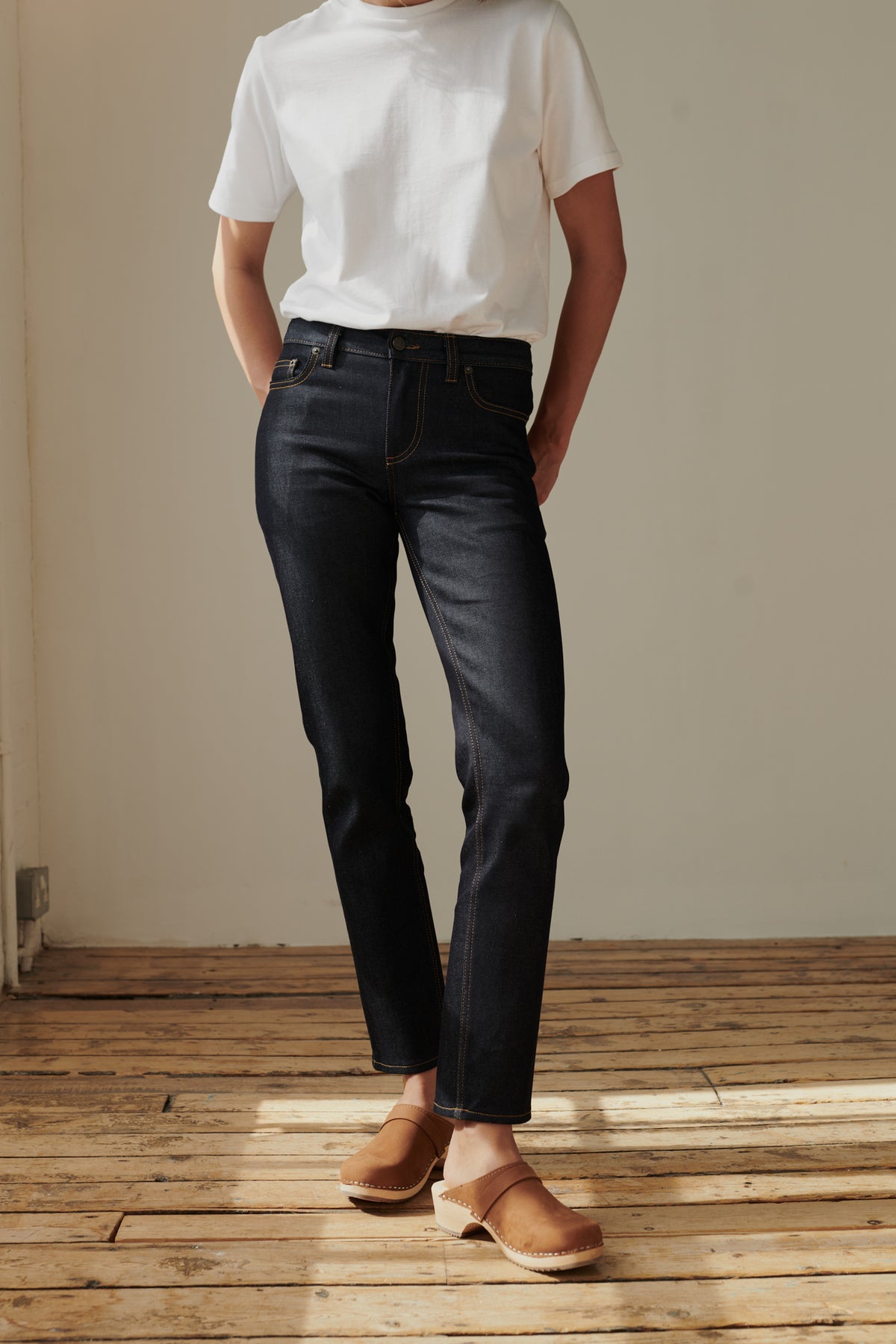 Shoulder down image of female wearing mid rise straight leg jean in Indigo