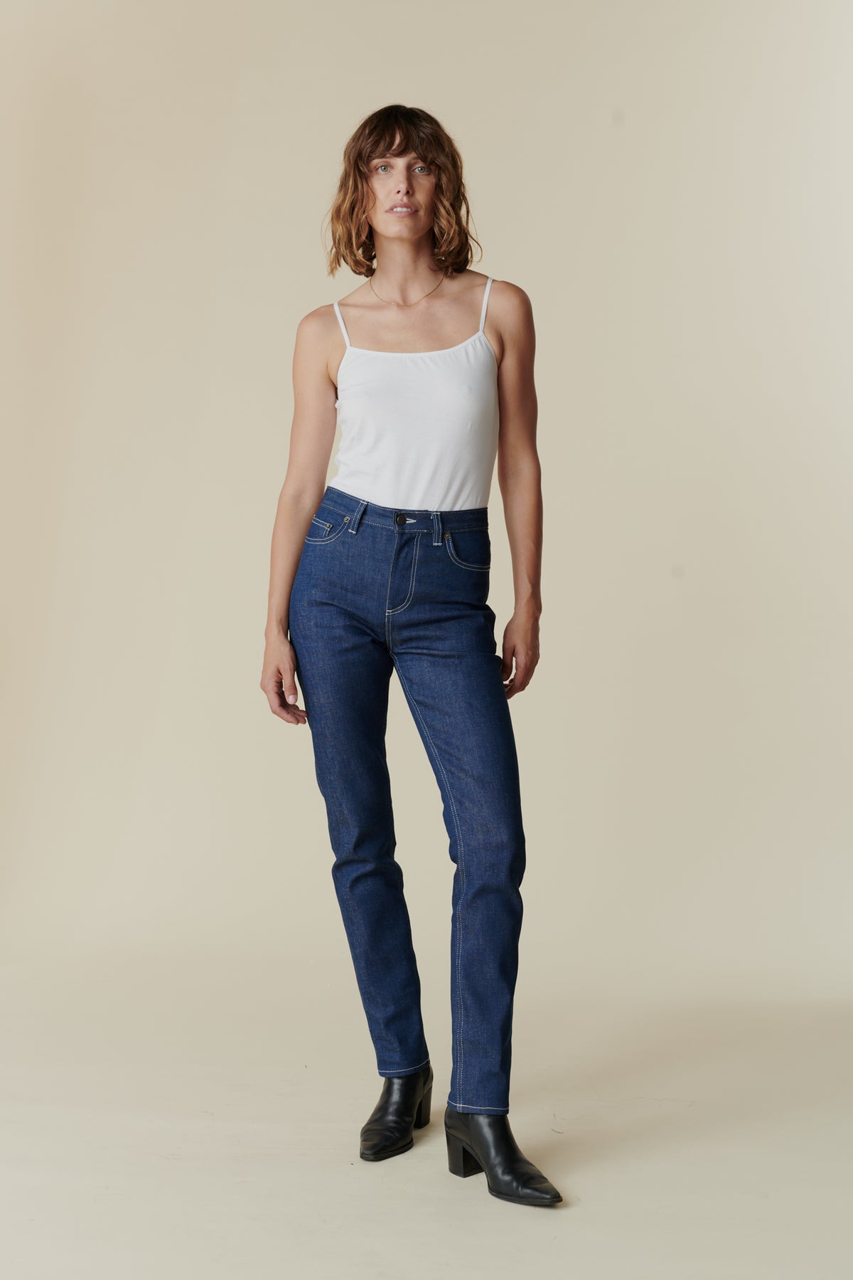 Front full body image female wearing straight leg high rise jean in blue.