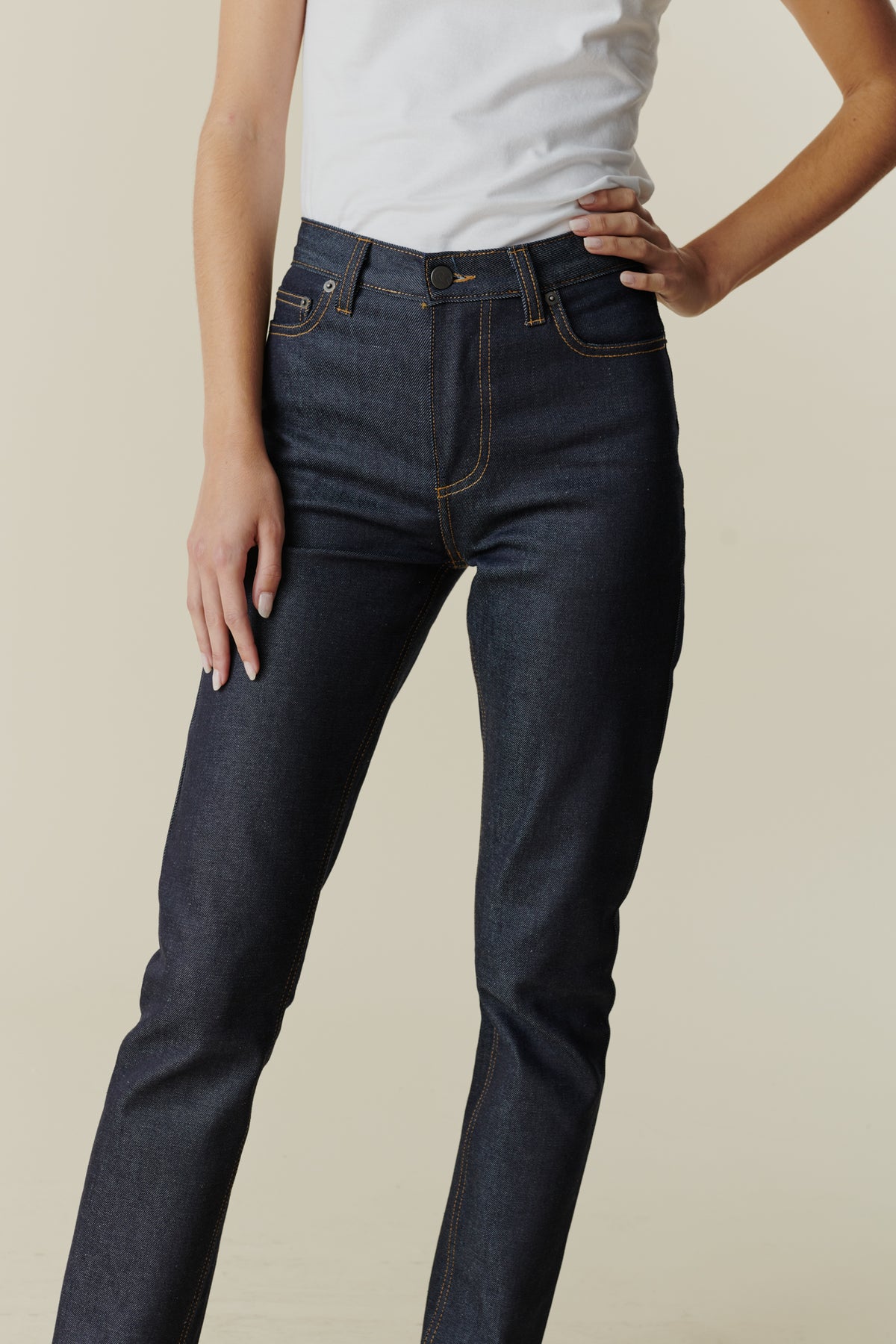 Female wearing straight leg high rise jean in indigo