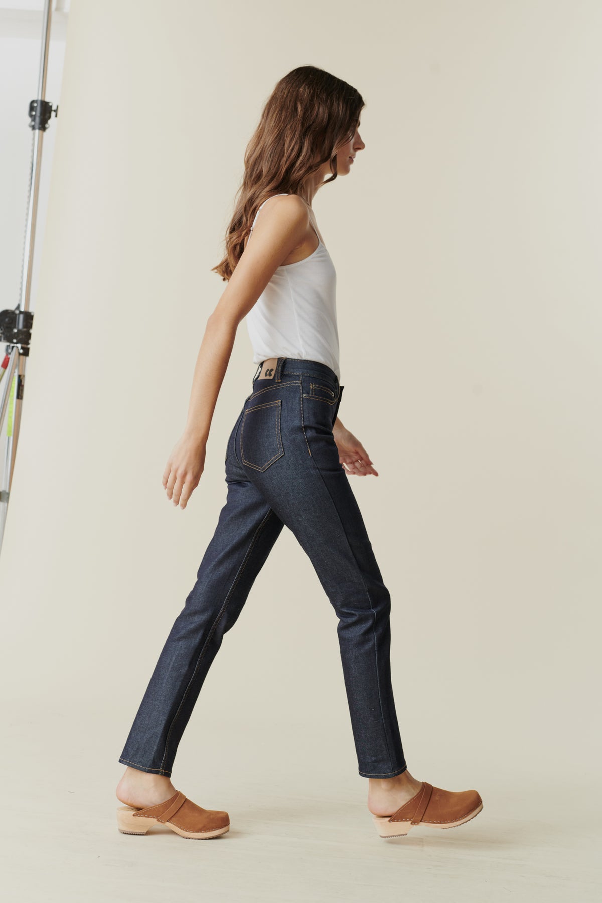 
            Full body side view of female wearing straight leg high rise jean in indigo.