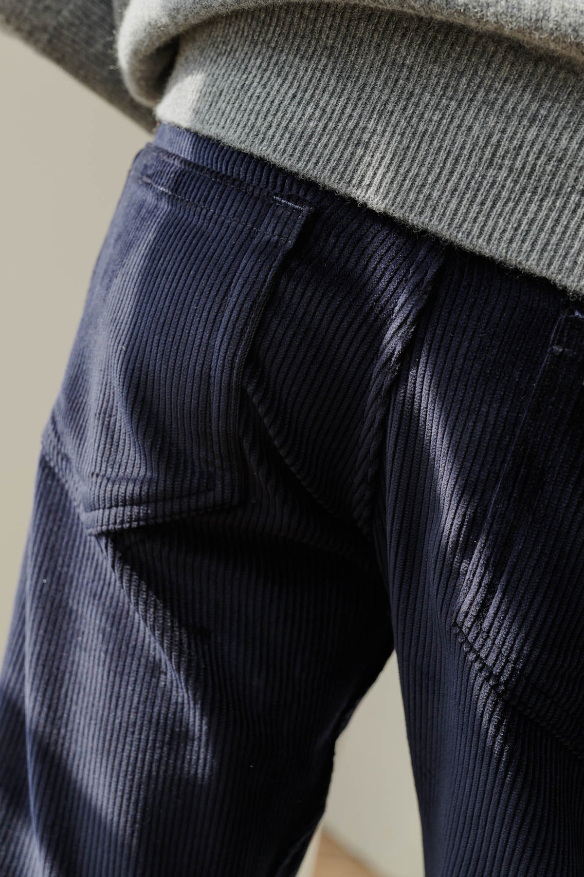 Male wearing five pocket cord trousers in navy back pockets detail