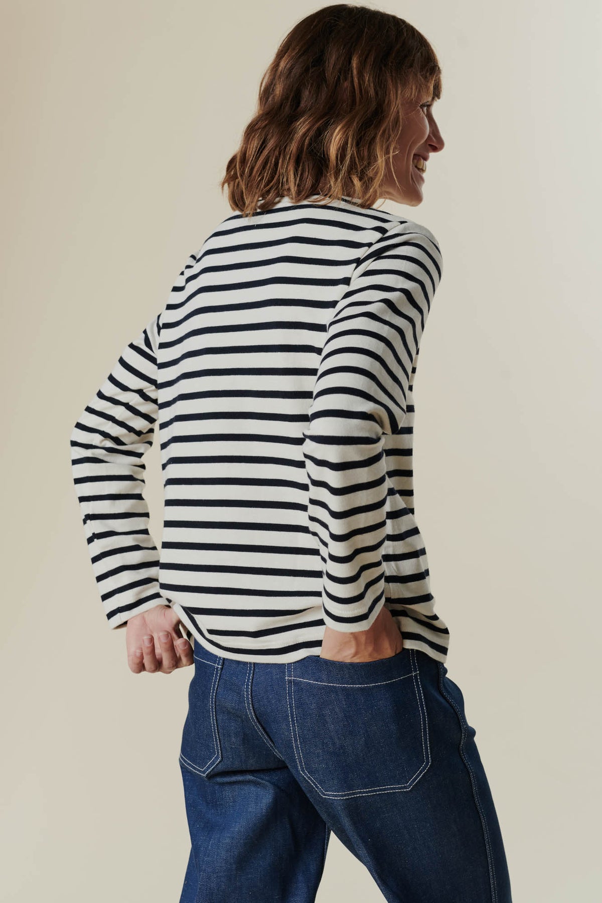Female wearing work jean in blue, showing two back pockets, paired with breton