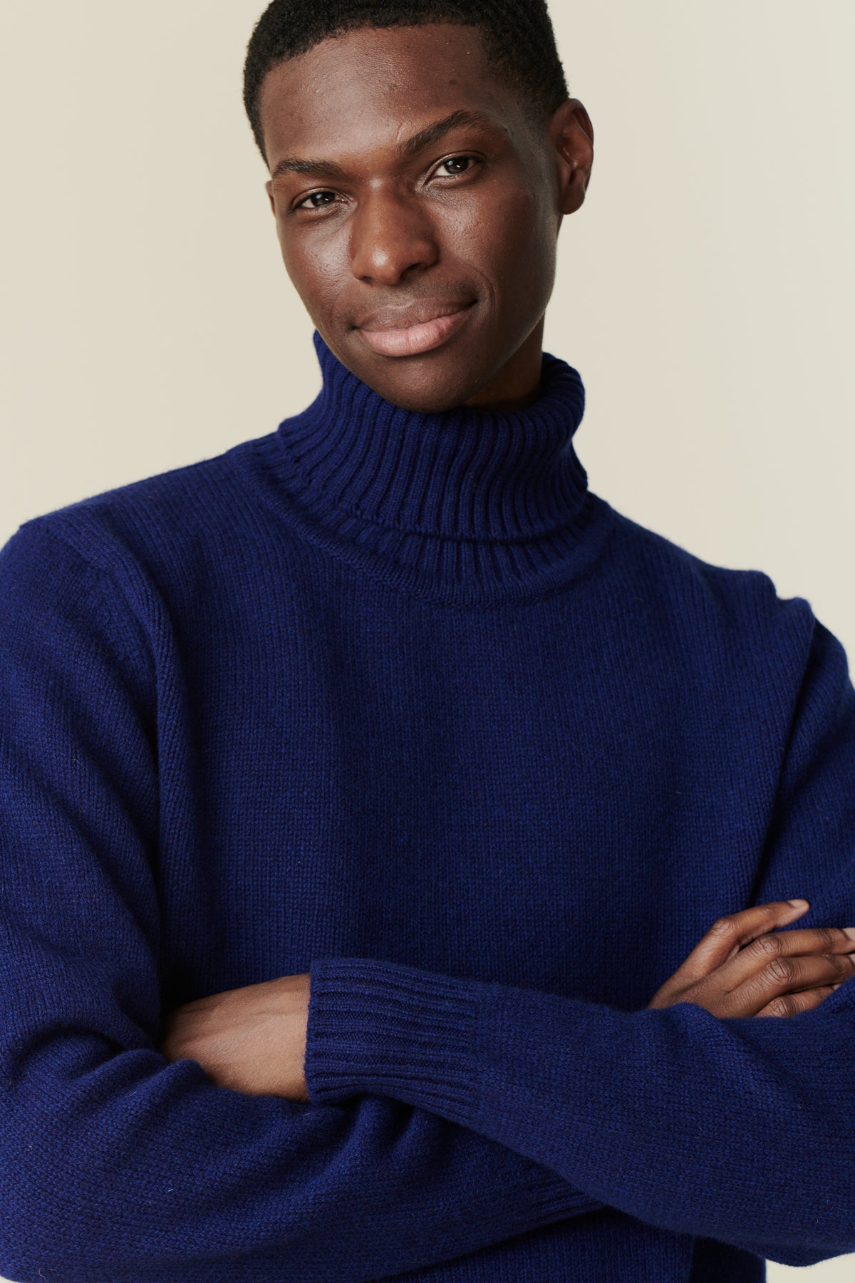 Portrait of black male wearing lambswool roll neck dark cobalt