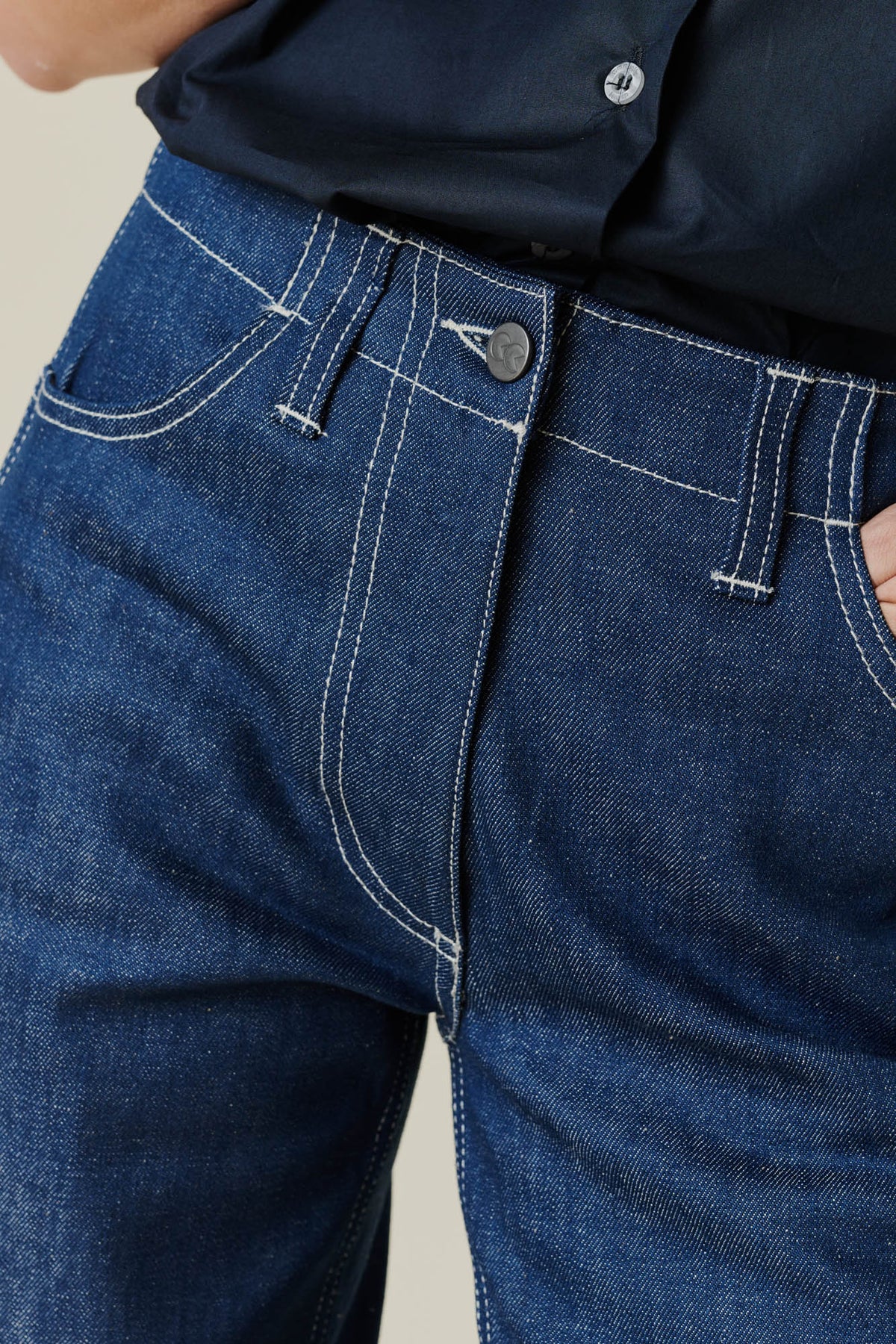 Female wearing work jean in blue. front fly, button, belt loop and pockets