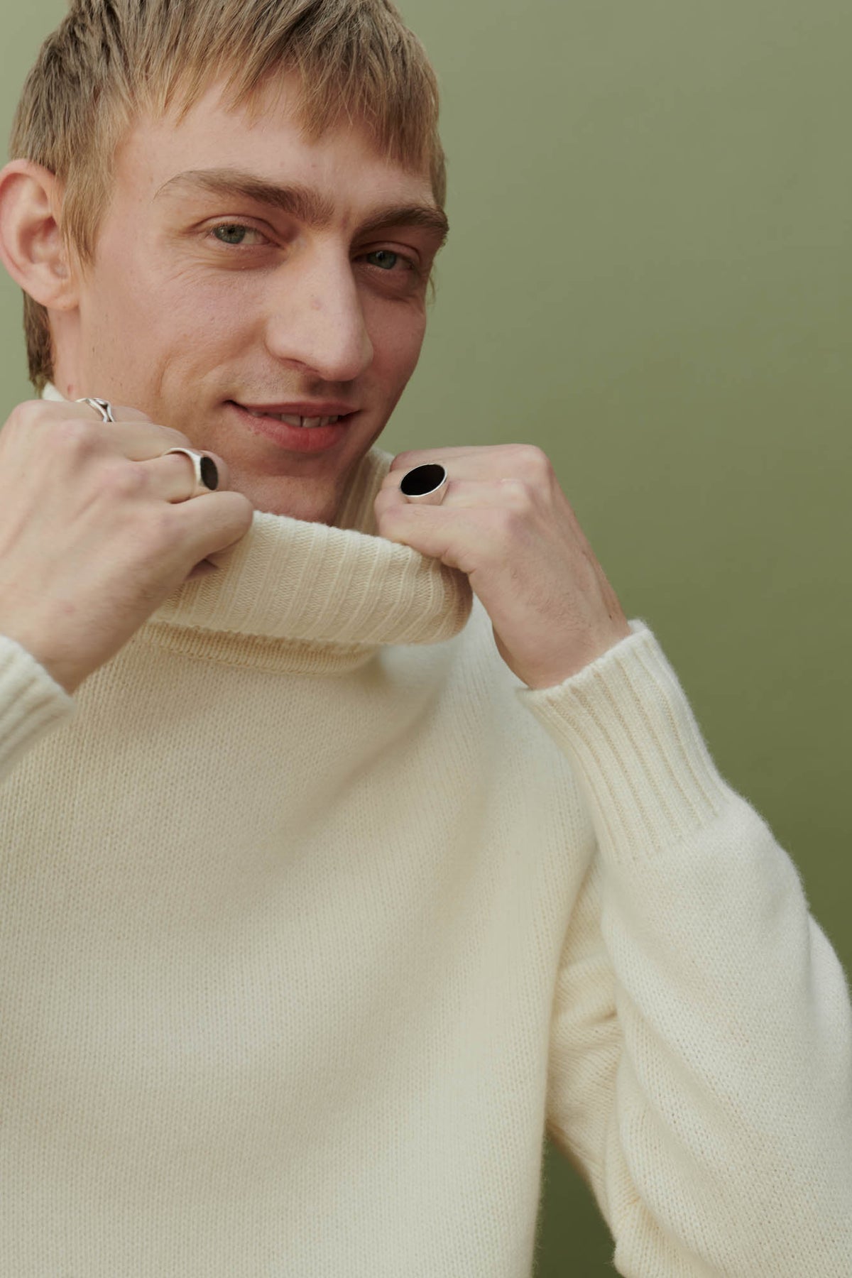 
            portrait shot of smiley white male wearing lambswool roll neck in ecru