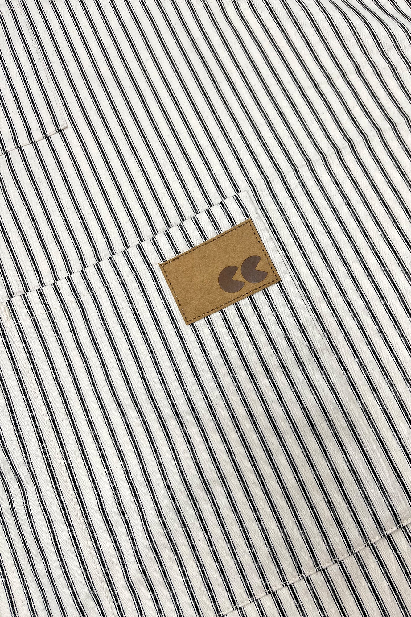 Close up of striped apron with a logo patch