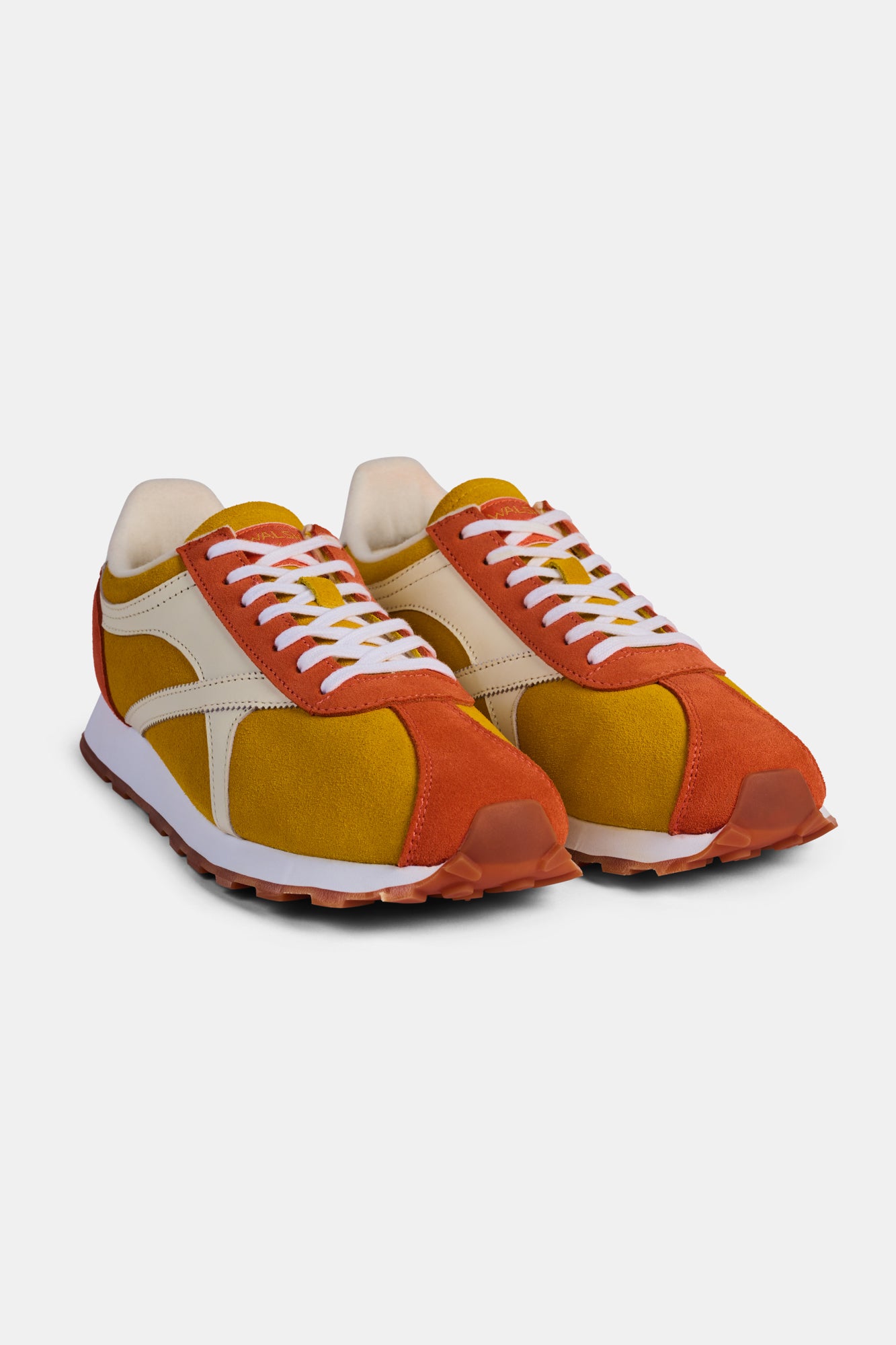Pair of orange and yellow trainers on a white background.
