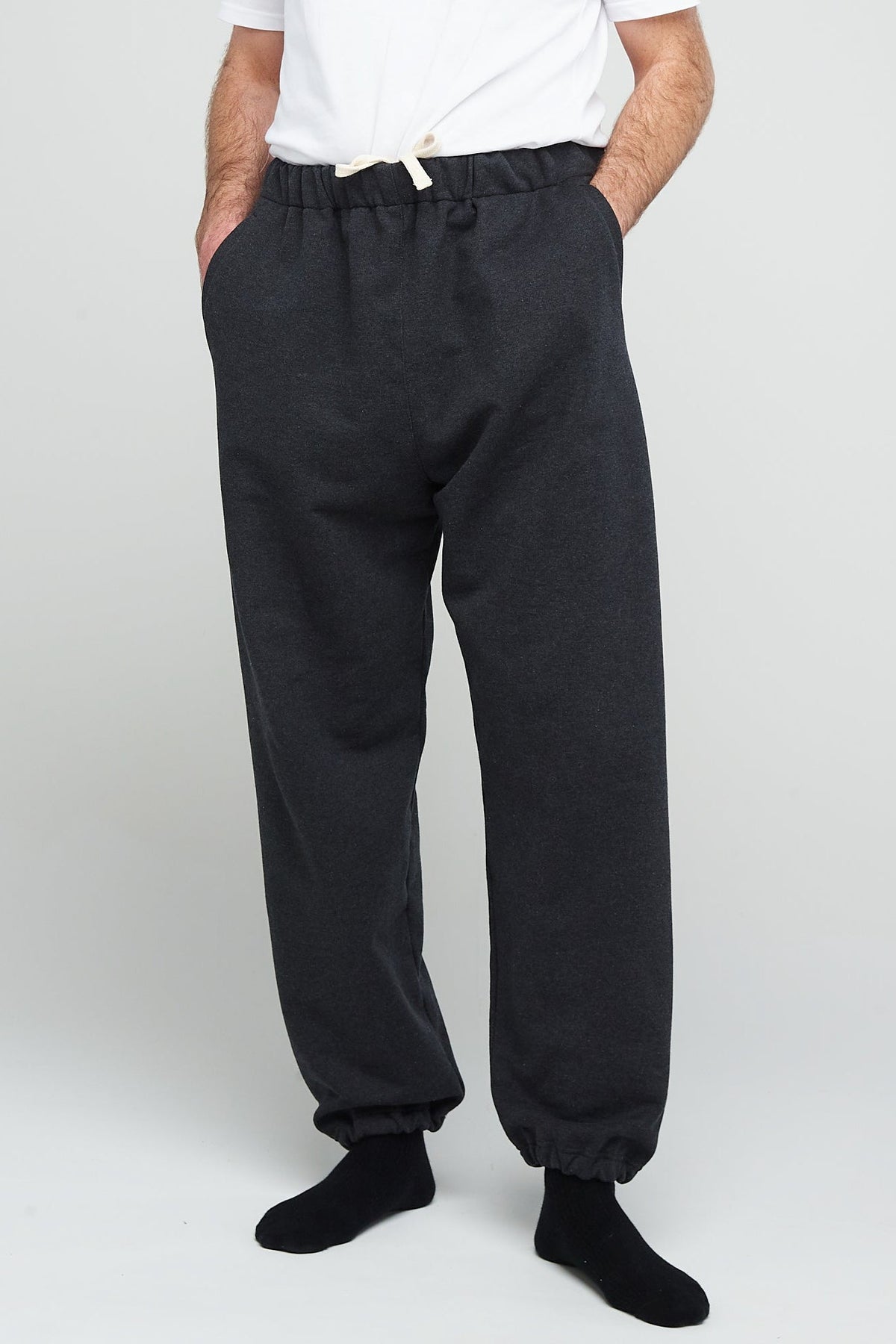 Waist down image of male wearing men's heritage sweatpants in Charcoal - Community Clothing with white short sleeve t shirt tucked in to show adjustable drawstring waist