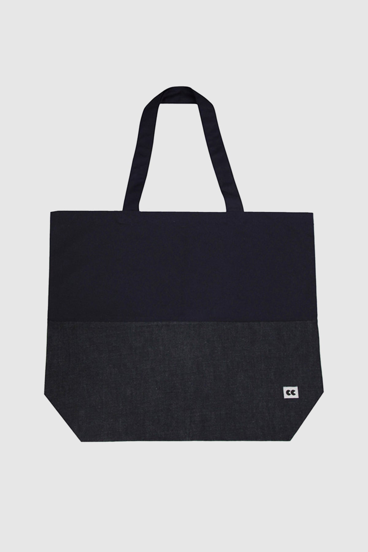 Flatlay of denim and navy tote bag with CC logo in the bottom right hand corner of the bag