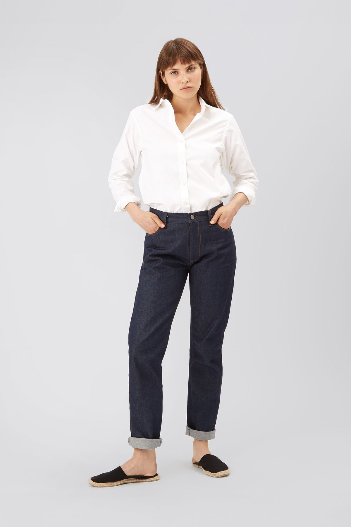 
            brunette female with fringe wearing white oxford shirt tucked into jeans