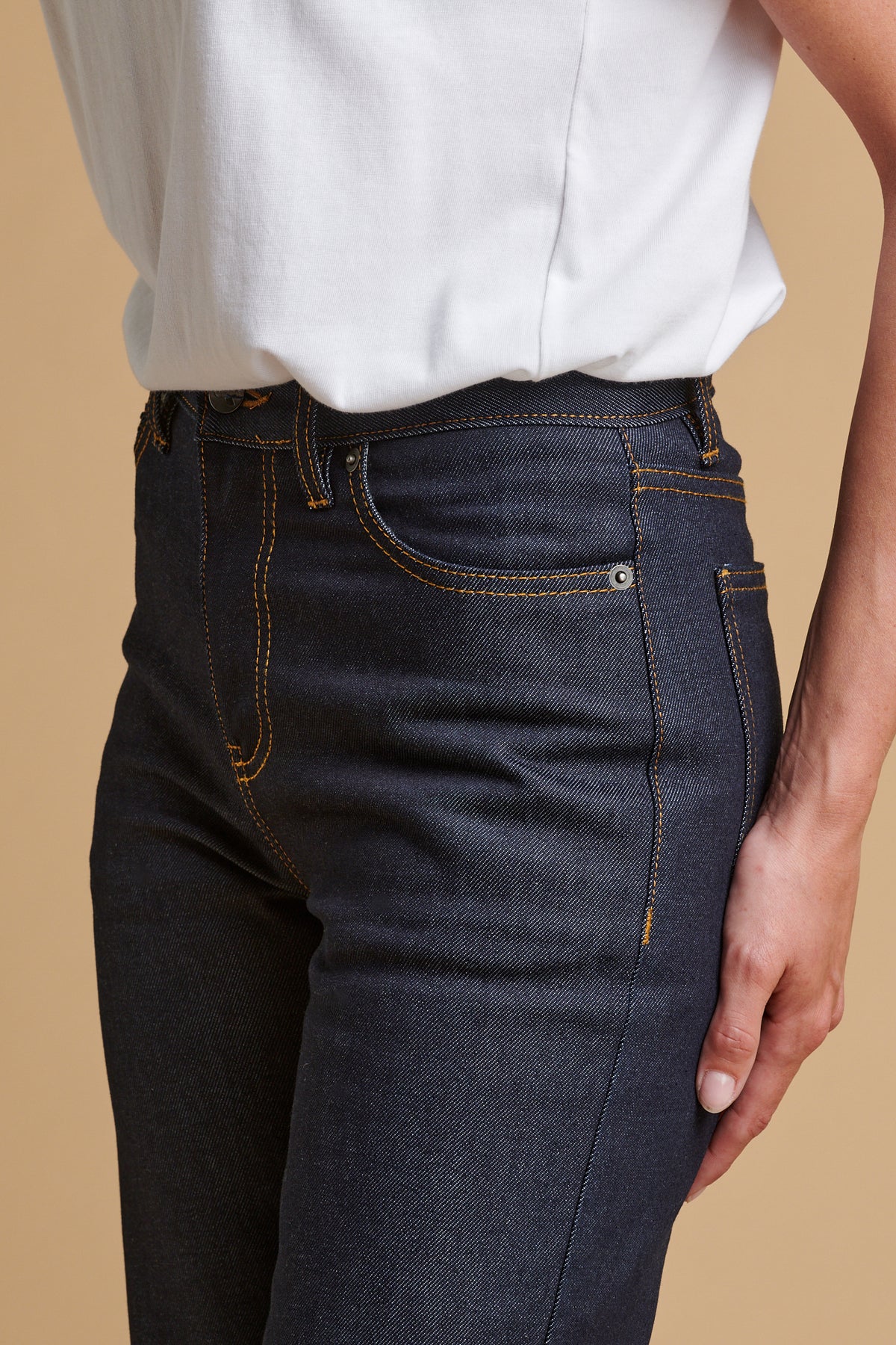 Detail shot of female wearing wide leg high rise denim jean in indigo.