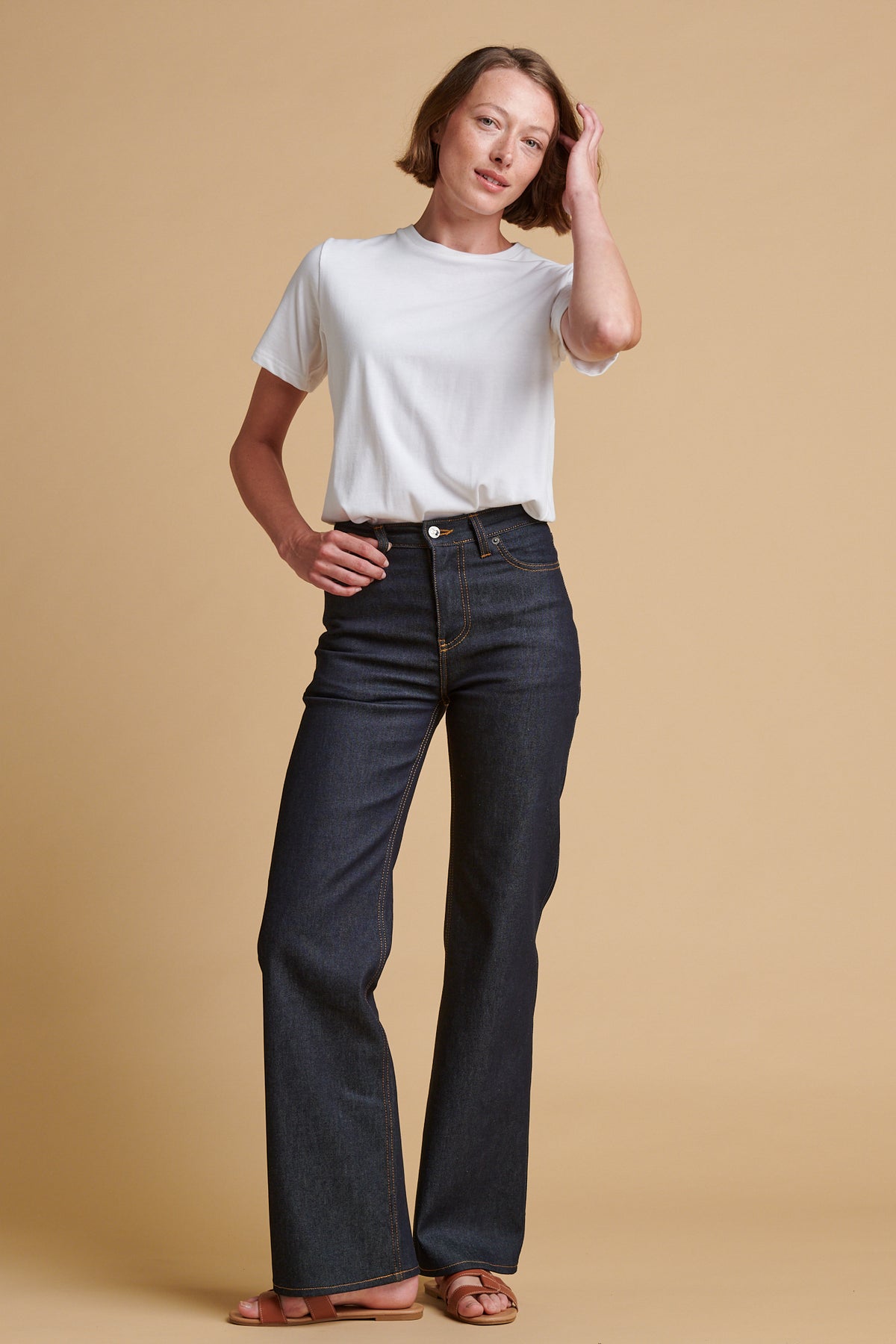 Female wearing wide leg high rise denim jean in indigo paired with classic short sleeve t shirt in white.